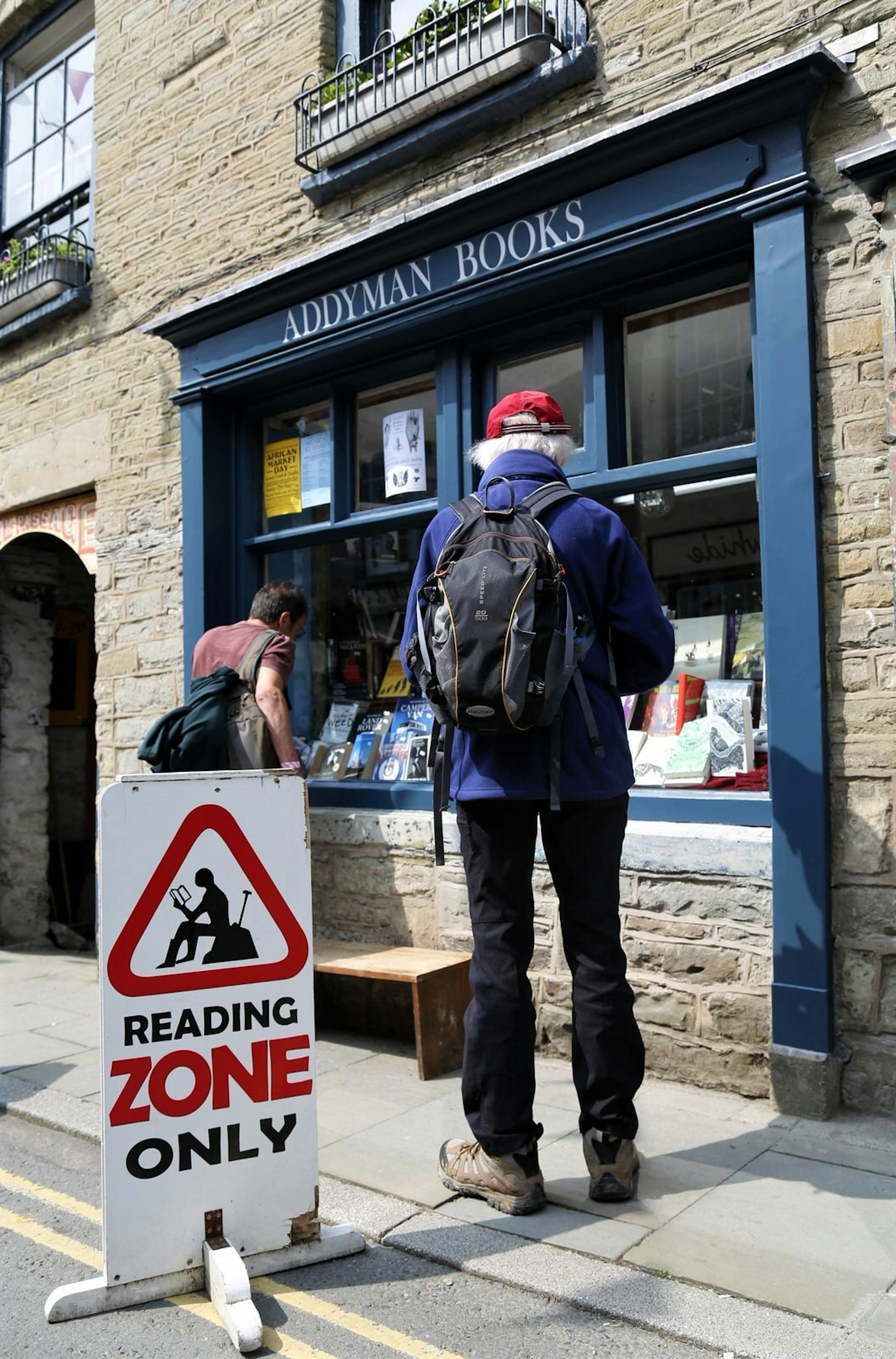 Man standing outside a book shop in Hay-On-Wye