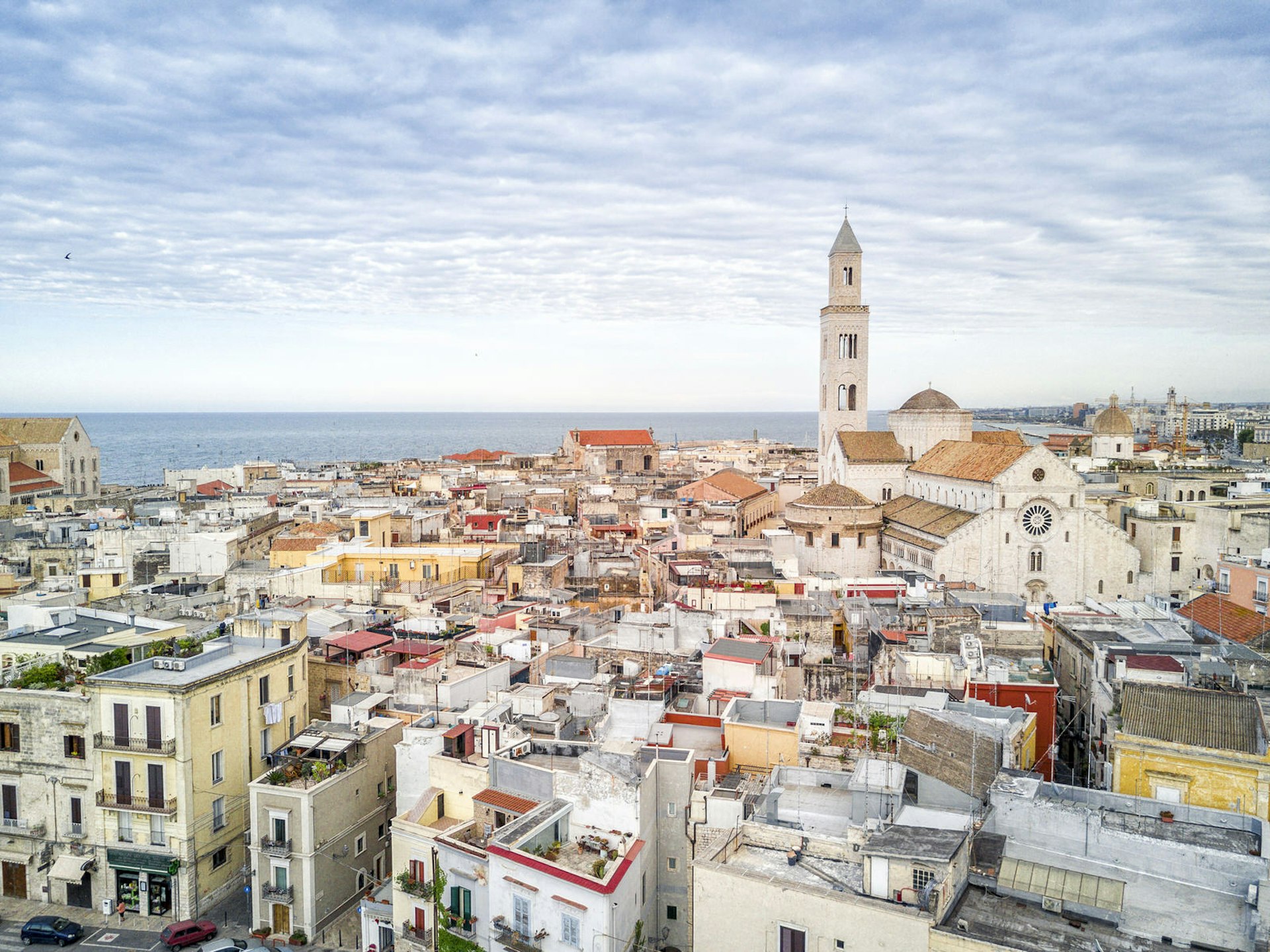 A view of the tightly packed buildings of Bari's Old Town, with Basilica di San Nicola on the right and the sea in the distance