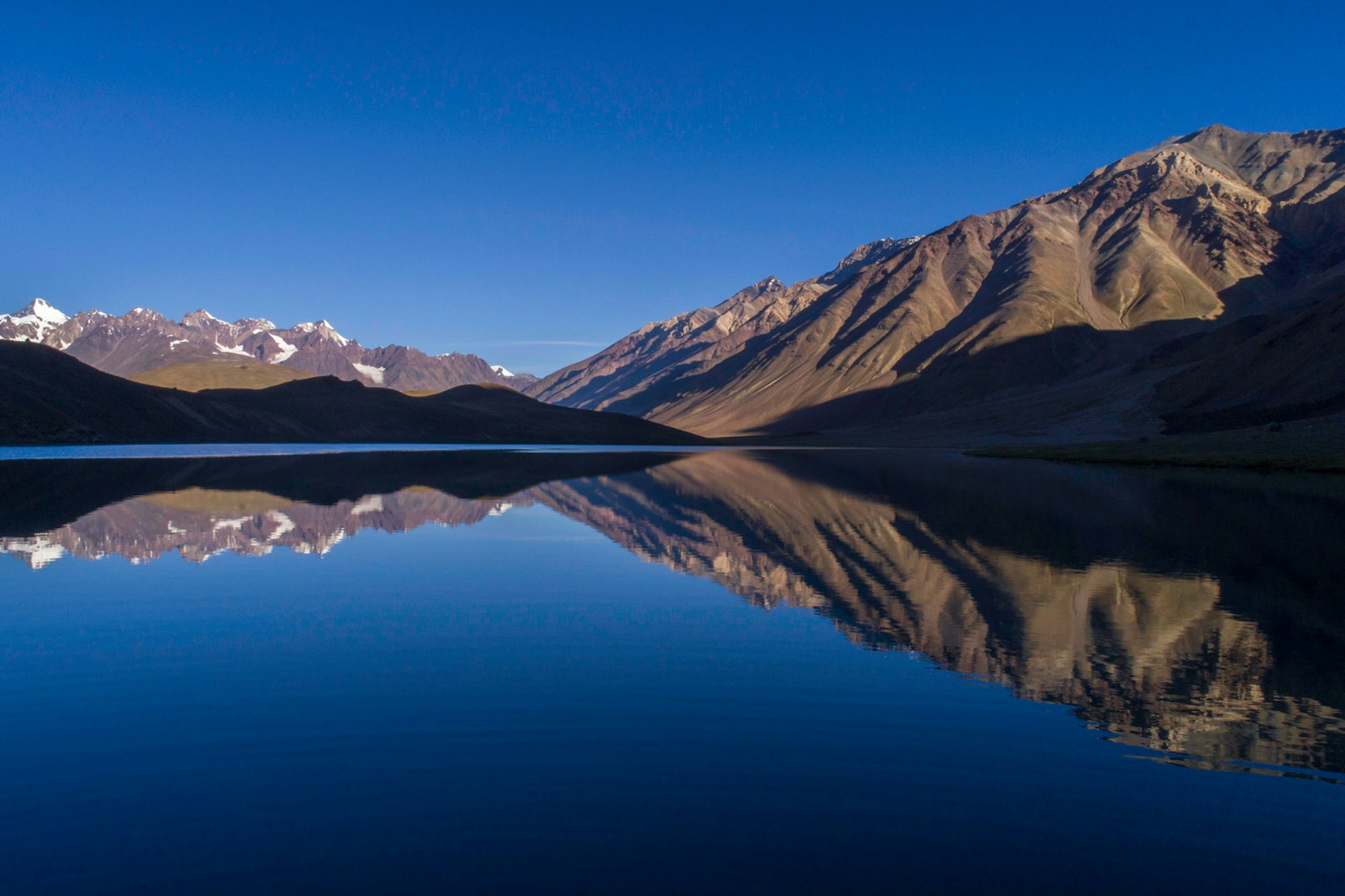 Chandratal Lake reflecting mountains on the horizon in Himachal Pradesh