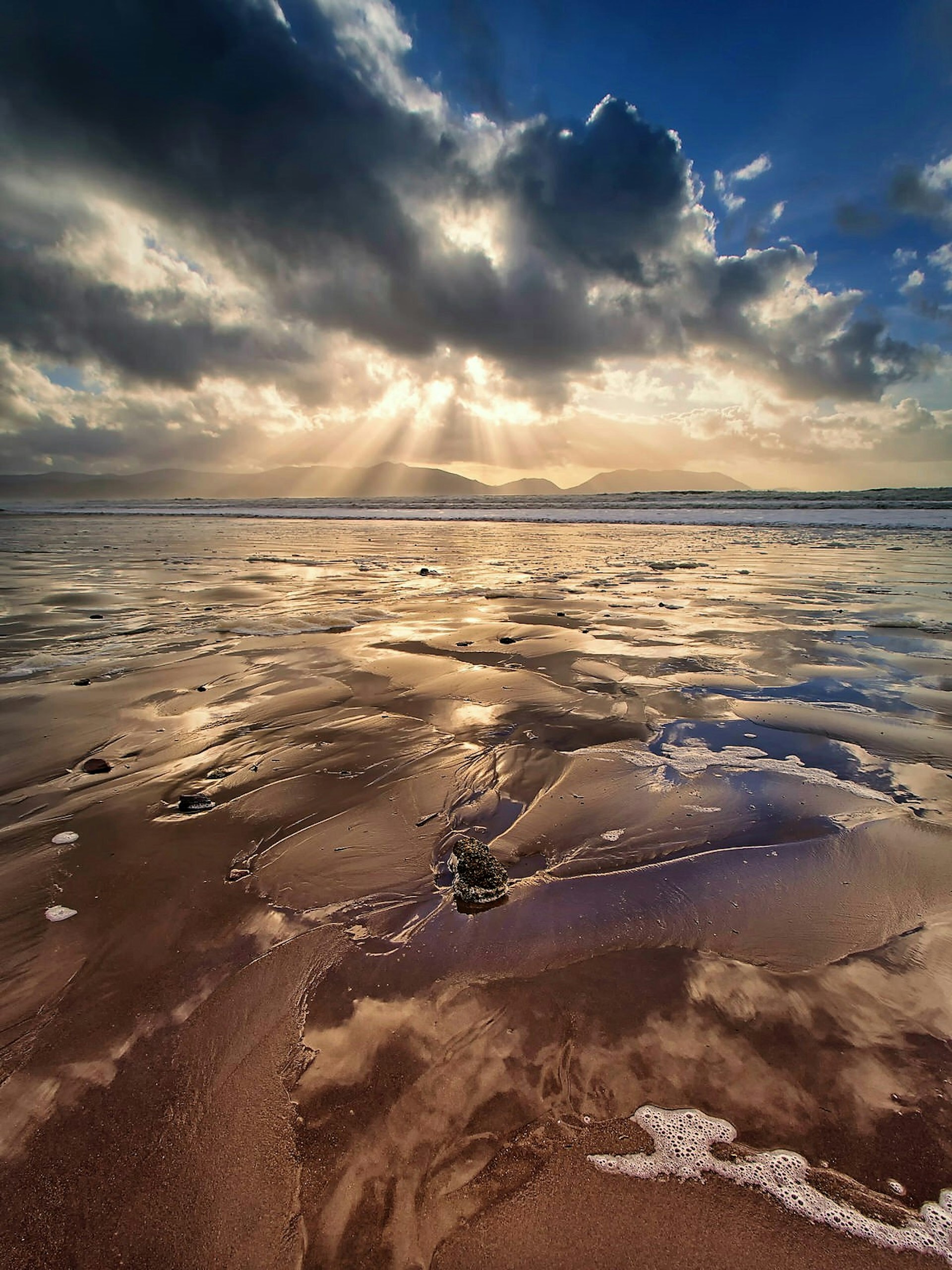The sun pokes through some clouds over Inch Beach