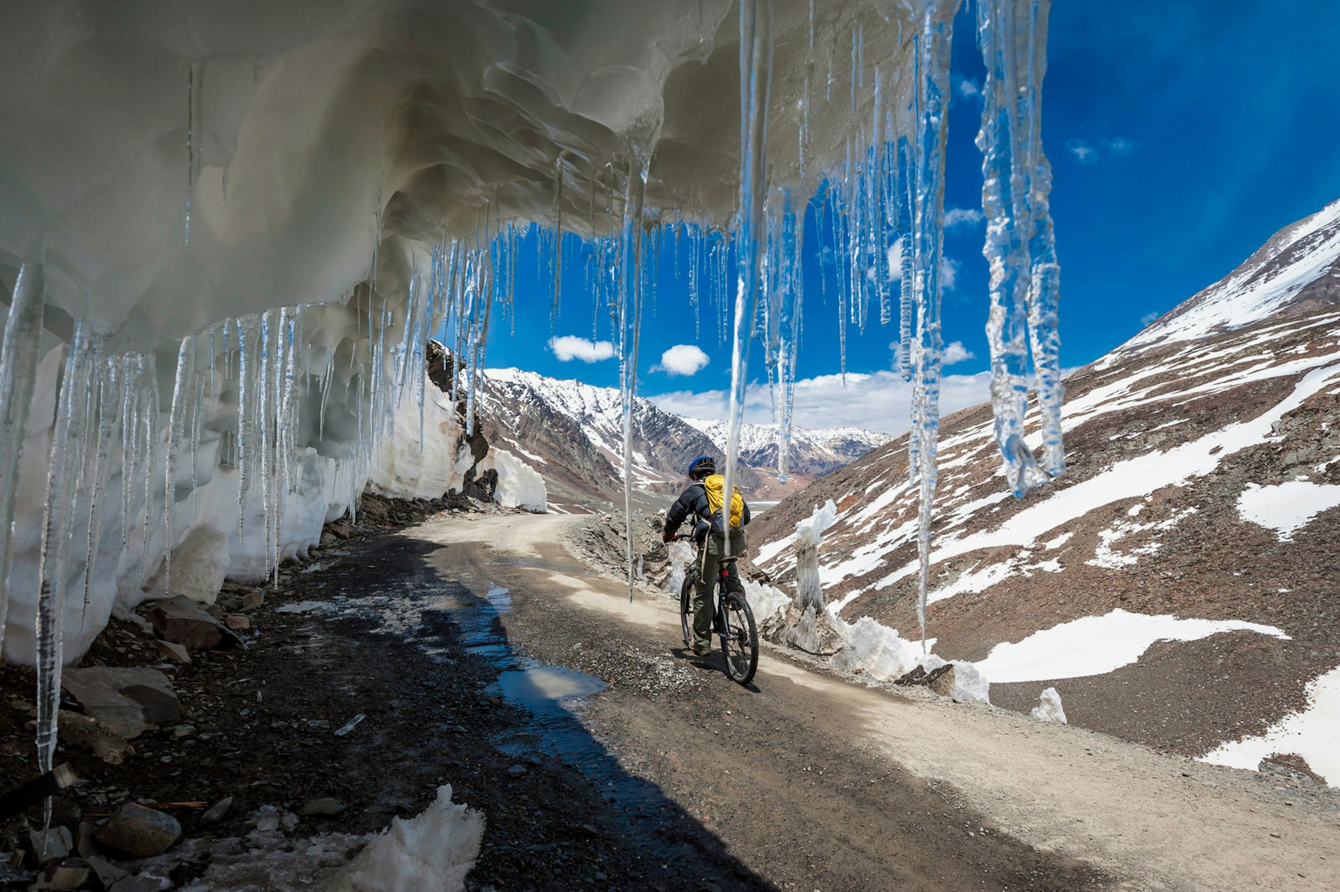 Mountain biker framed by icicles near the Rohtang La in Himachal Pradesh