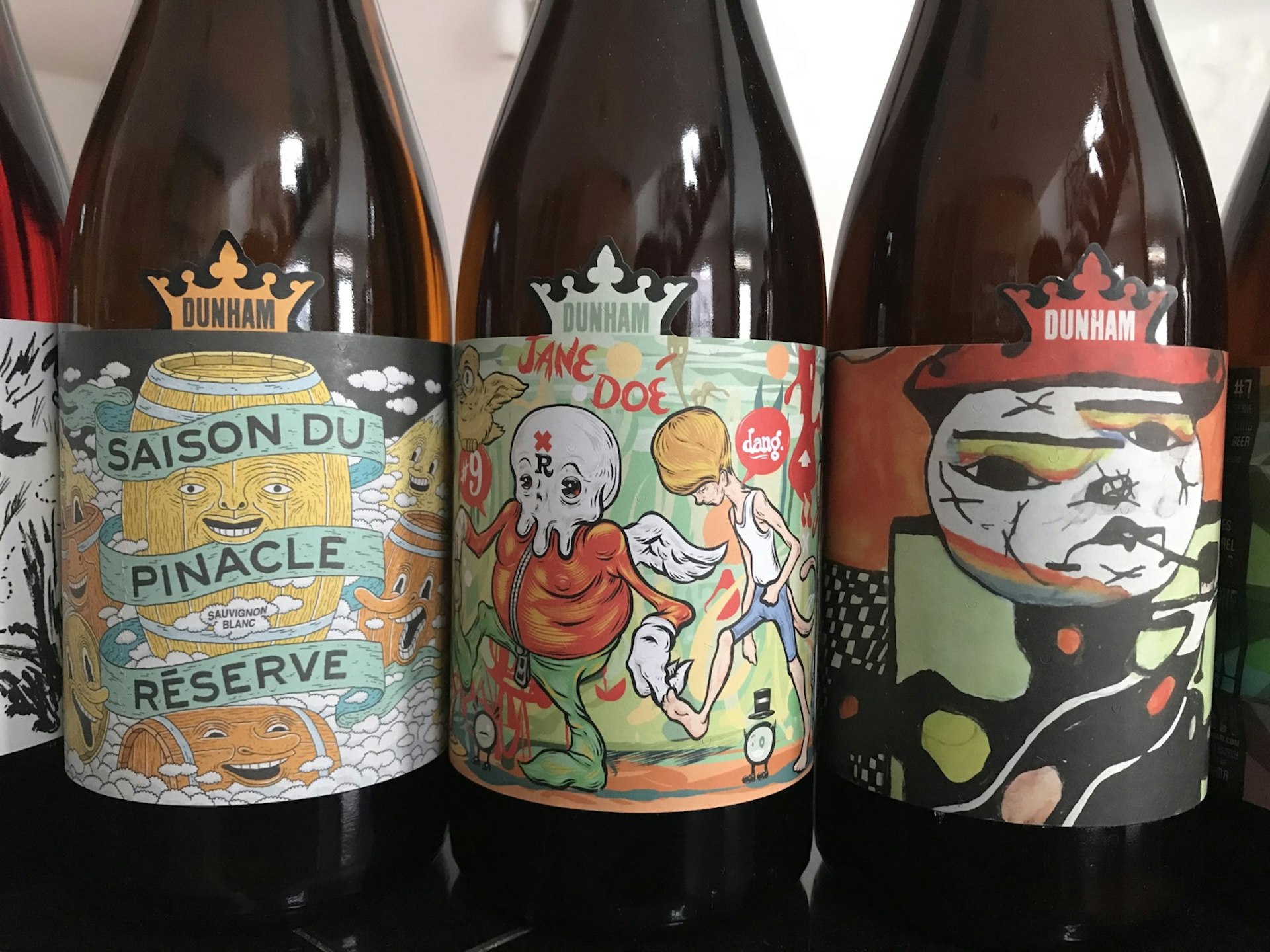 A row of beer bottles with bright, artistic labels