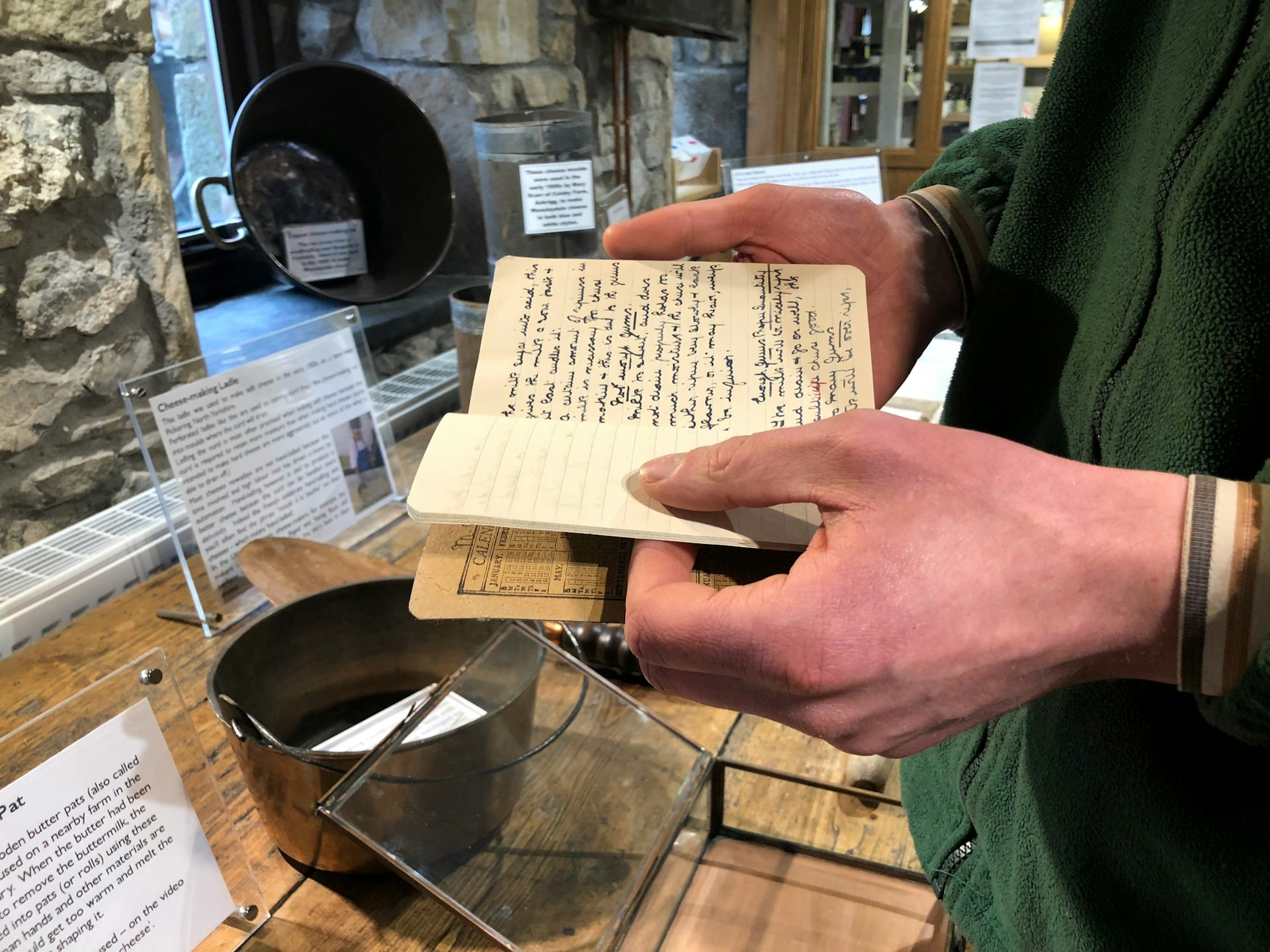 Andy at Courtyard Dairy holds a notebook with his great great grandmother's cheesemaking notes