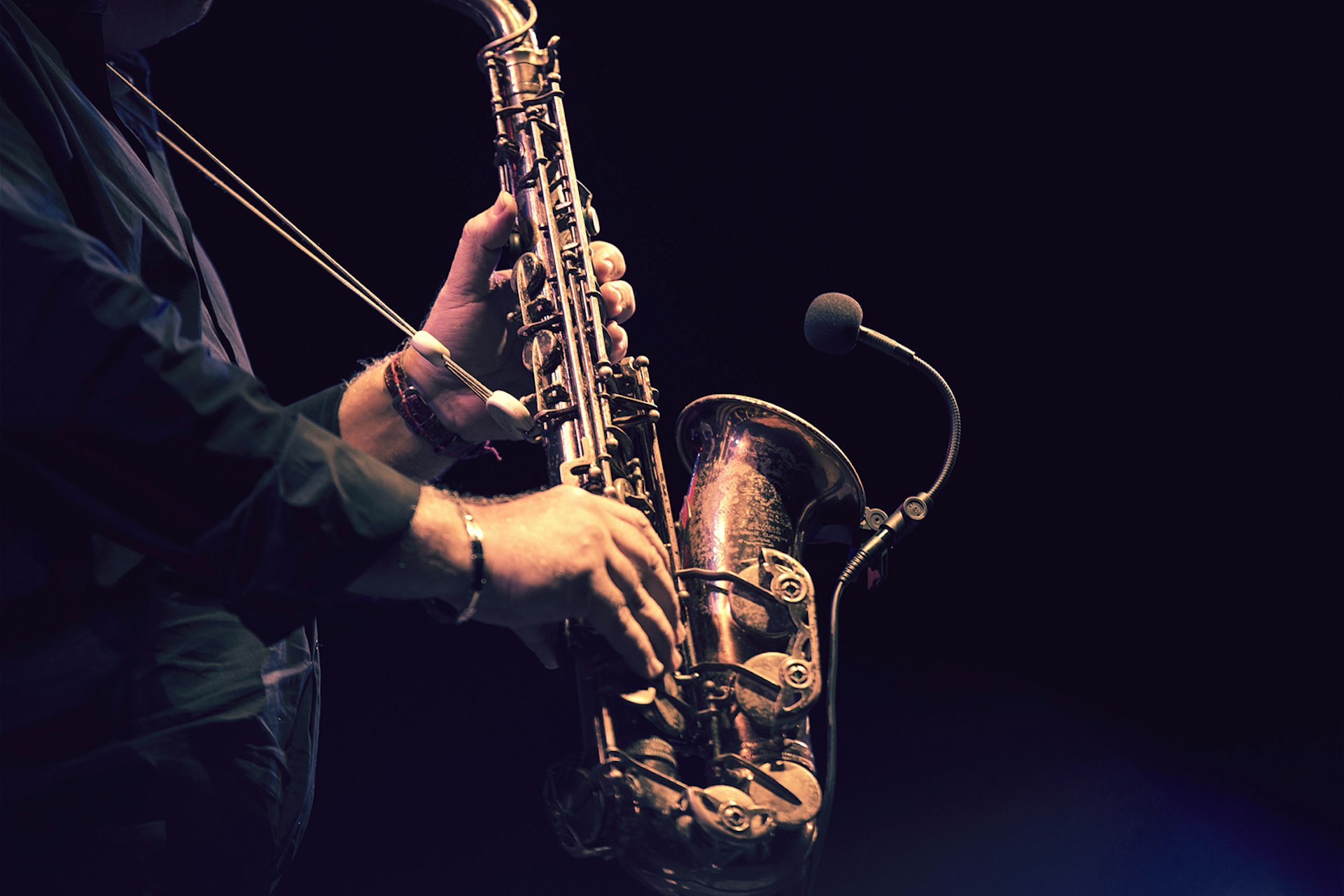 A close-up of a saxophone as a man plays it