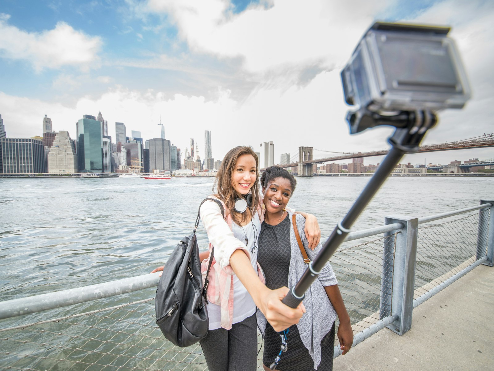 Two women taking a selfie with the New York skyline in the background