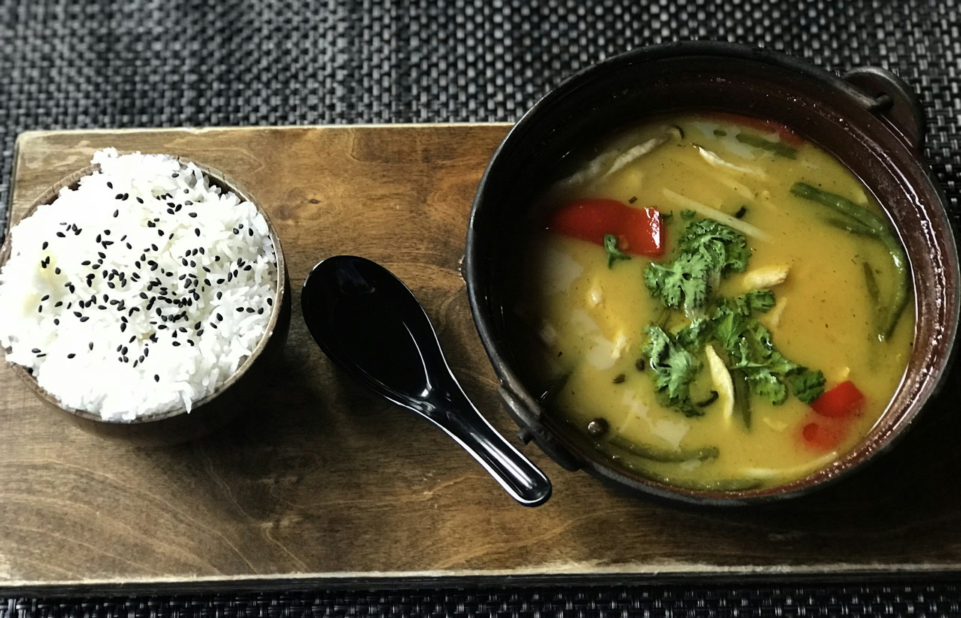 A bowl of rice and an asian soup are separated right and left by an asian soup spoon in Mont-Tremblant.