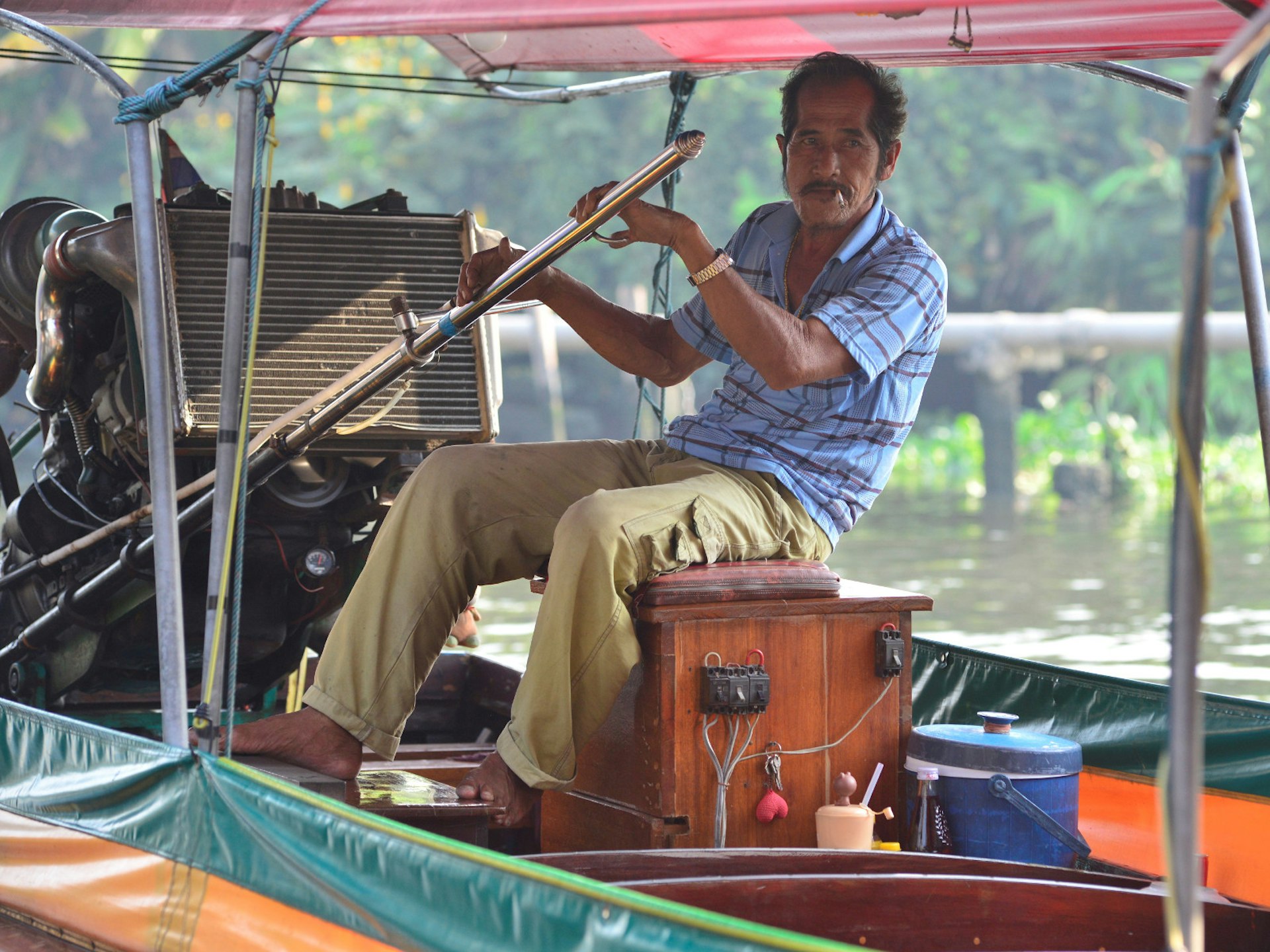 A longtail boat captain navigates the waterways of Bangkok.