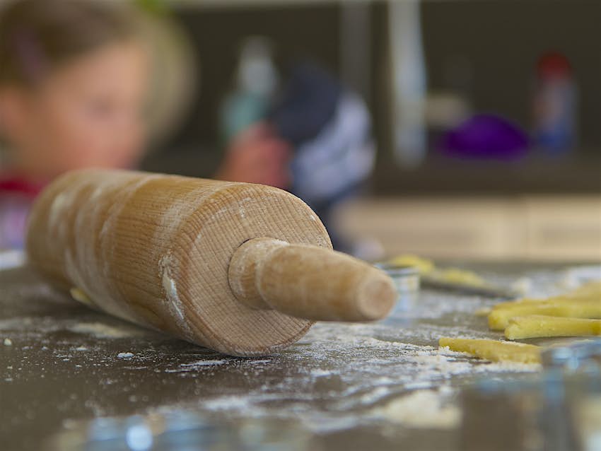 A young child learning to make pasta