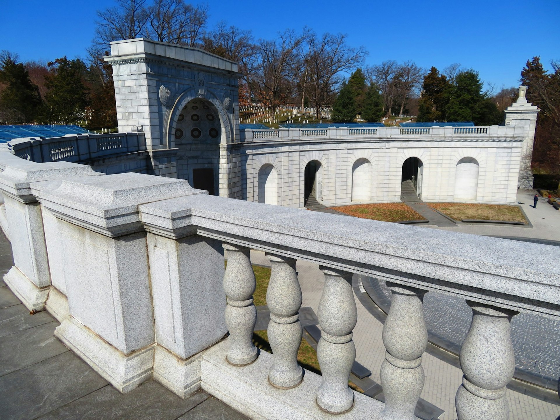 A curved wall with arches and pillars marks a memorial in Washington, DC