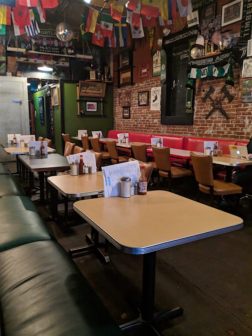 Rows of diner tables are seen in a cozy brick-walled cafe