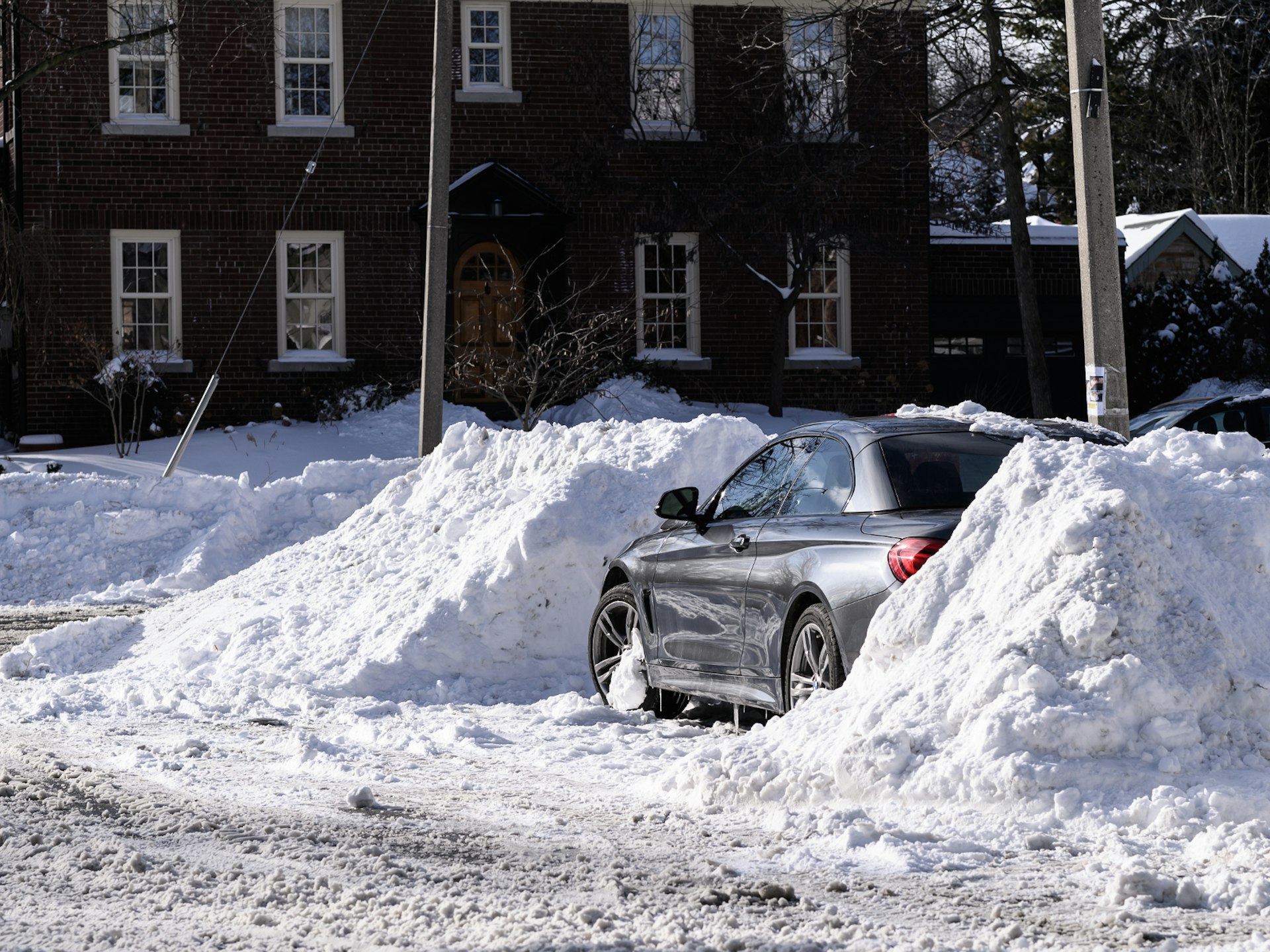 A car parked between two huge dug-out snow banks in Chicago
