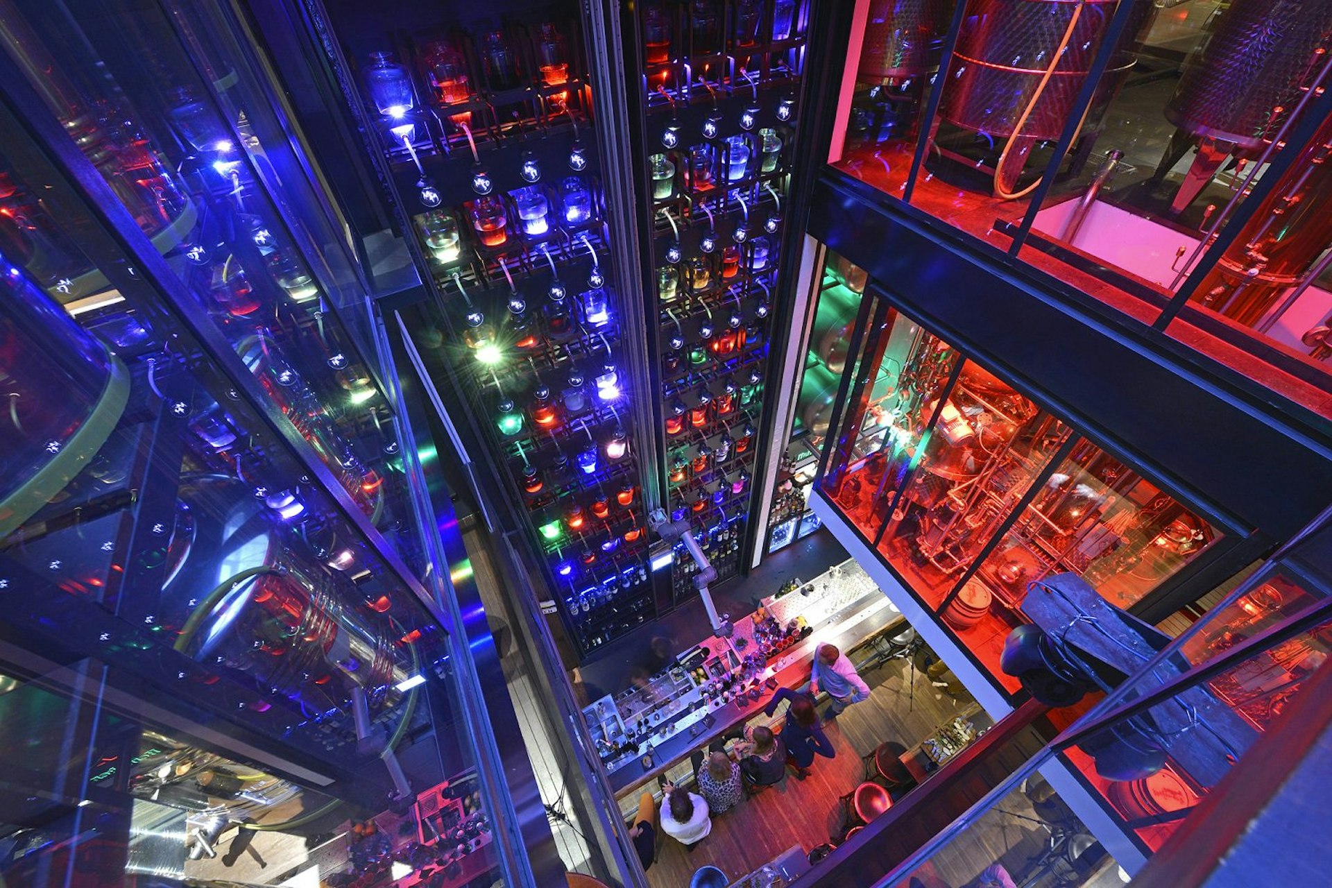 The vertical cocktail bar at Mr. Mofongo's, Groningen, is illuminated with green, blue and red lights. Bottles line the walls from floor to ceiling and some is even poured with the help of a robotic arm © Mr. Mofongo