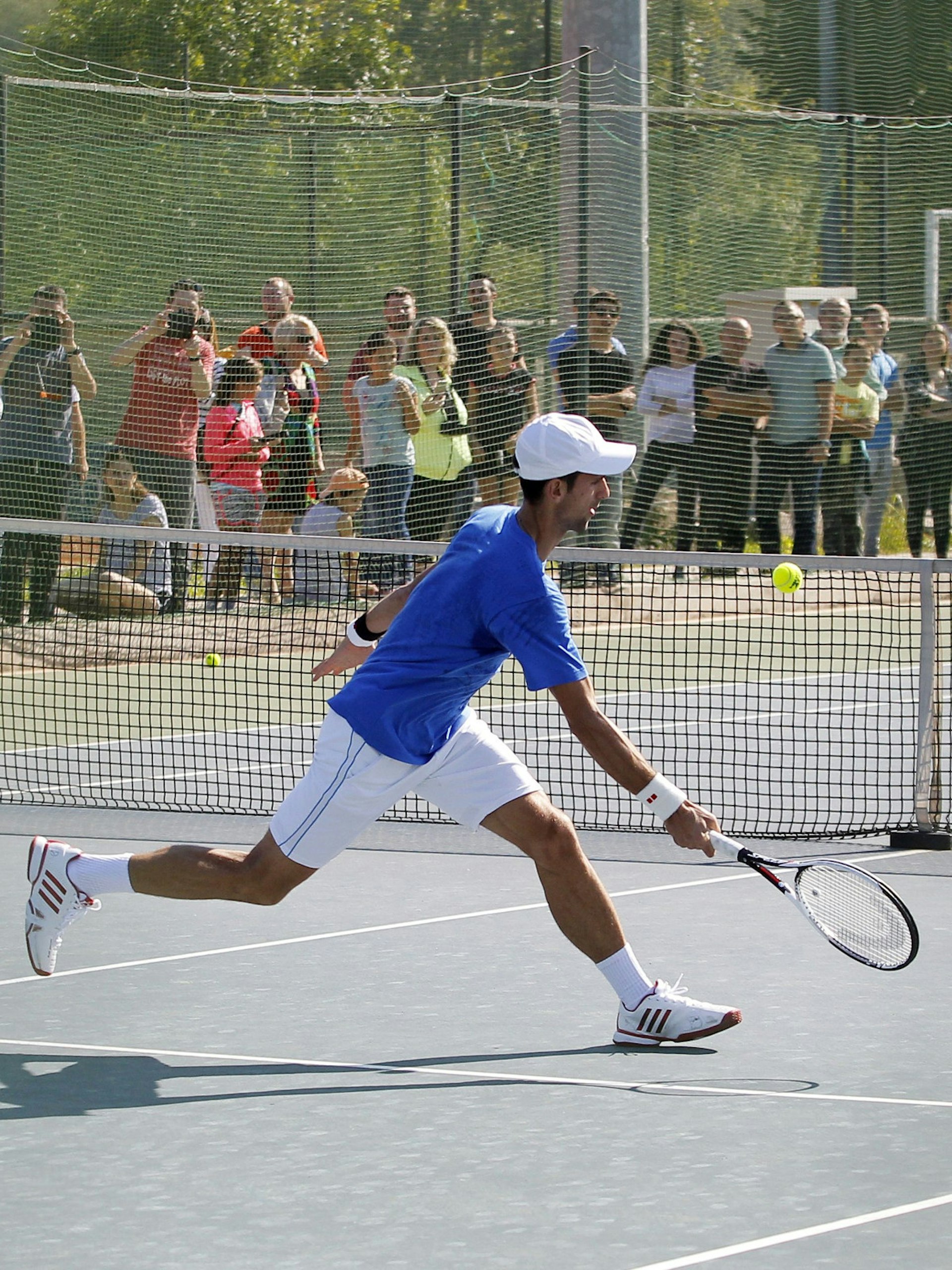 People watching world number-one tennis player Novak Đoković practicing at an open tennis court in Belgrade