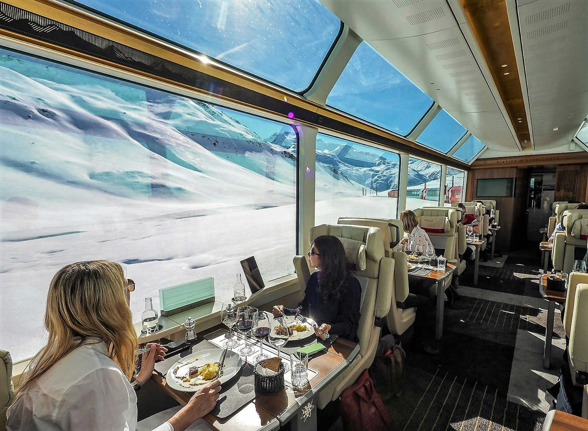 Passengers on the Glacier Express enjoy the food and views in Excellence Class
