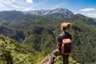 Features - Traveler with dreadlocks hiking in Sutjeska National Park and looking at Skakavac Waterfall and Peru?ica Primary Forest,Bosnia and Herzegovina, Europe