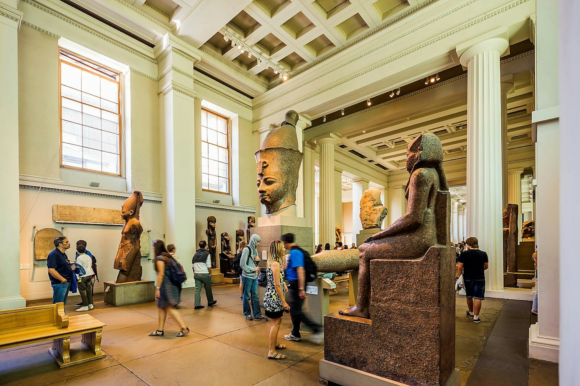 Visitors wander between statues in the British Museum's Egyptian sculpture gallery