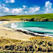 A couple walk across an empty beach in Shetland