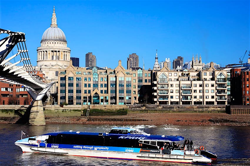 A Thames Clipper boat glides past St Paul's Cathedral on the river