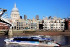 A Thames Clipper boats glides past St Paul's Cathedral on the river
