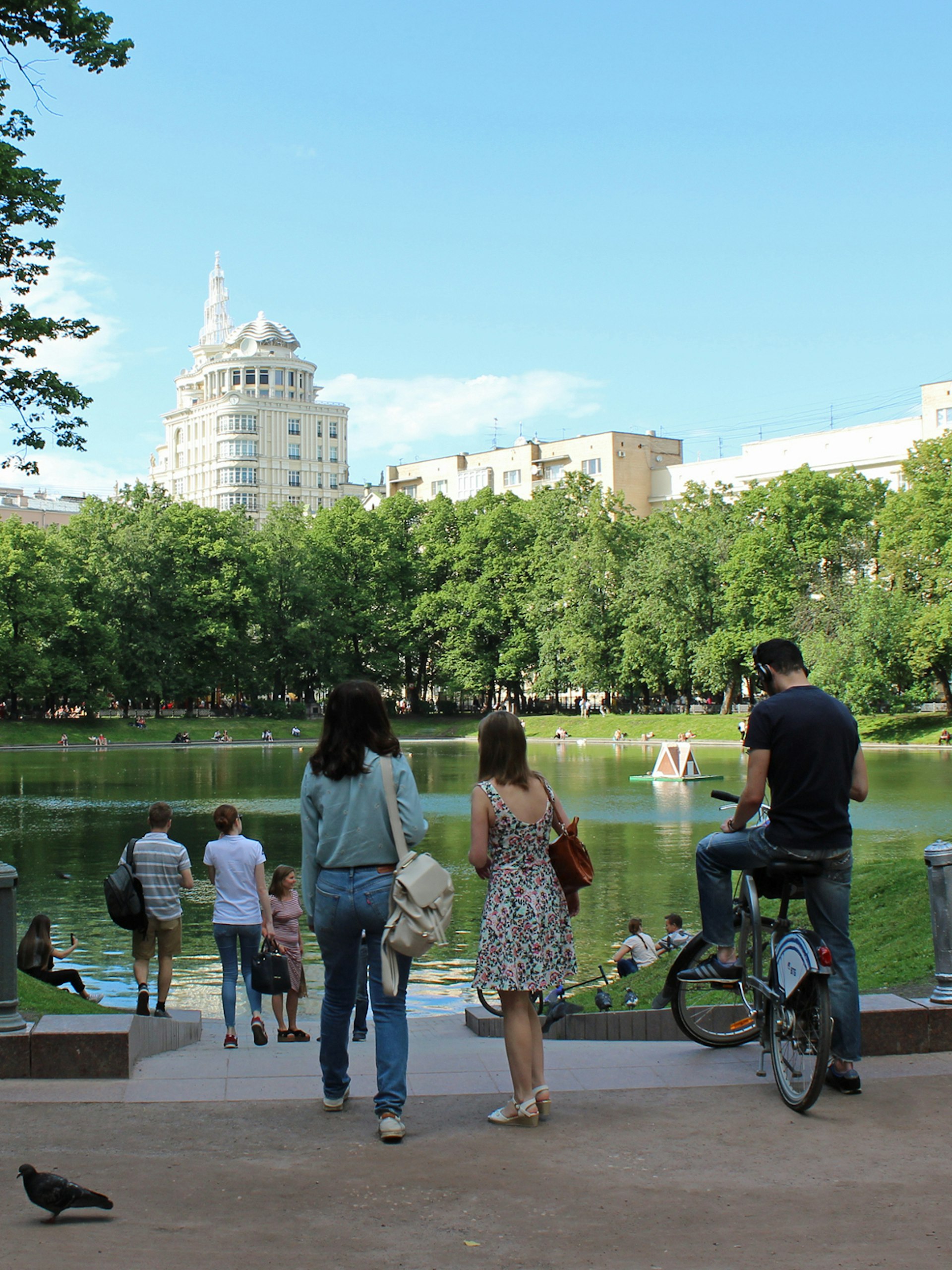 People chilling out at a pond in central Moscow on a summer day