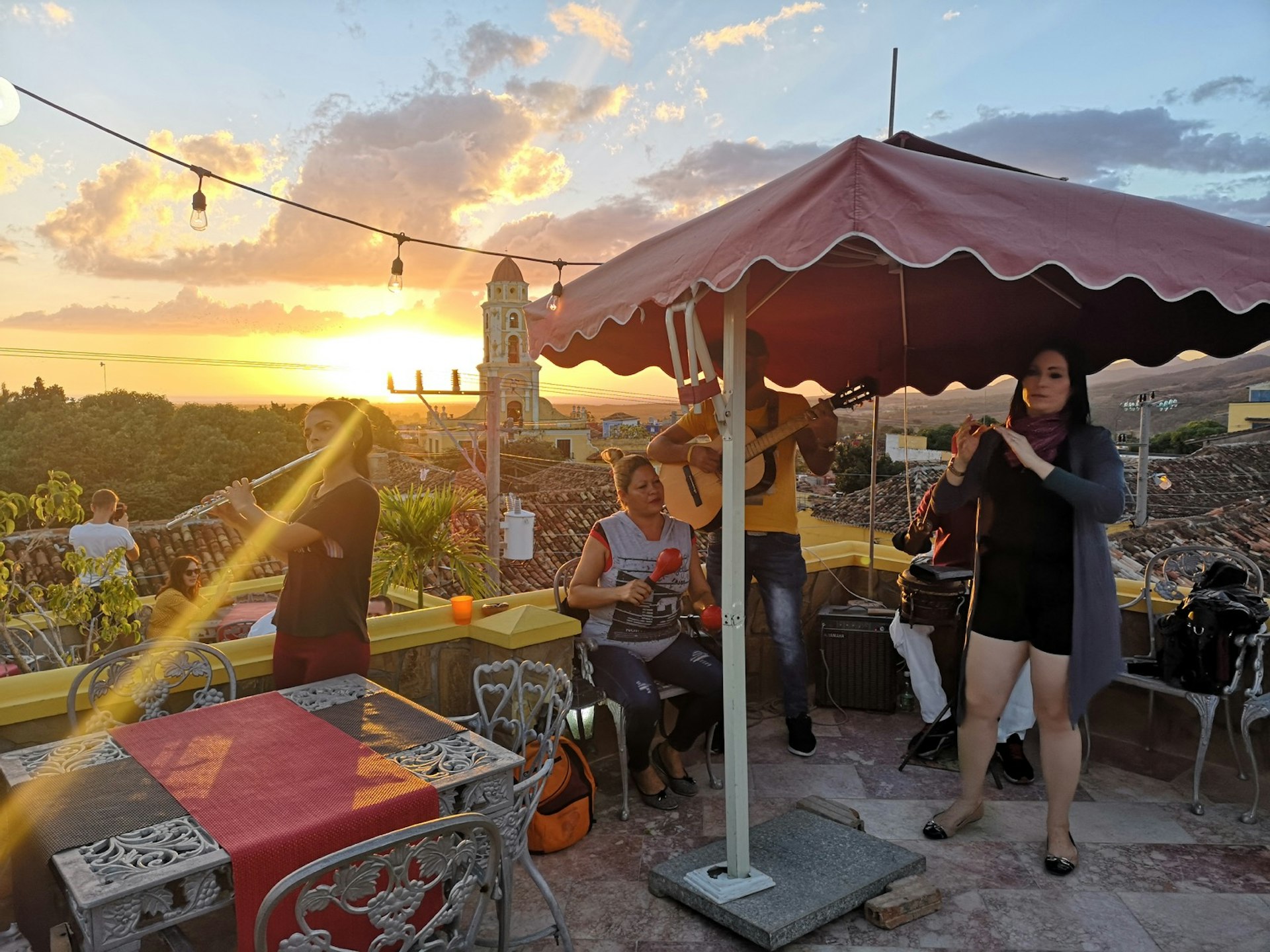 Salsa band performs on a rooftop cafe as the sun sets in Trinidad, Cuba 