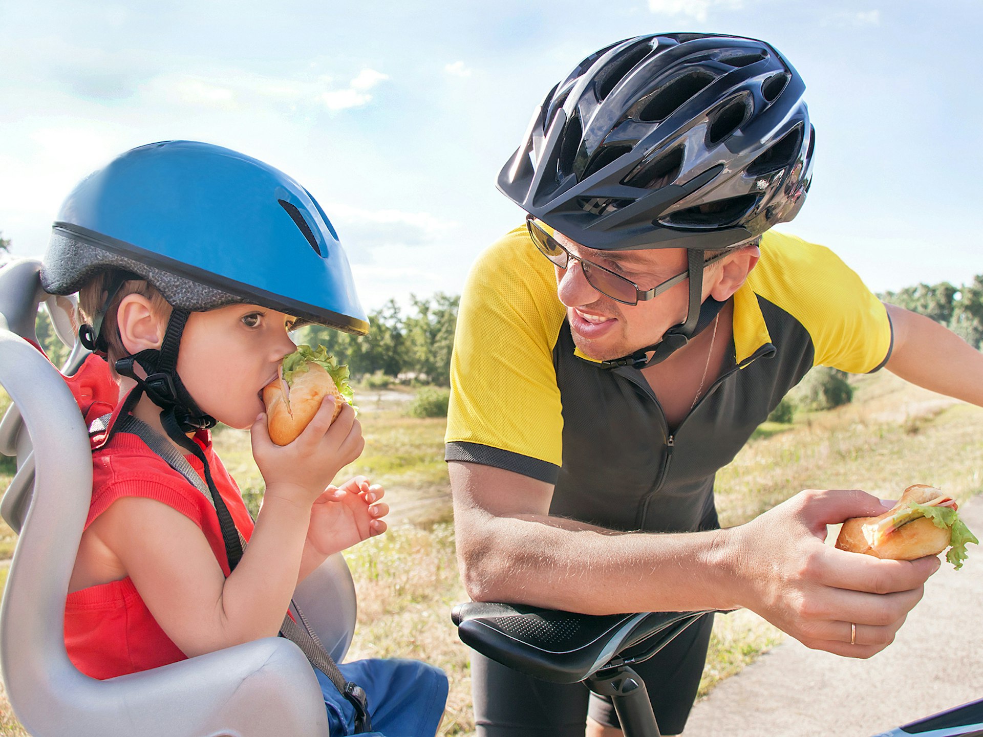 A father and son stop for a sandwich on a cycling trip