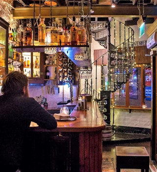 A man enjoys a drink at the bar of the Wee Pub