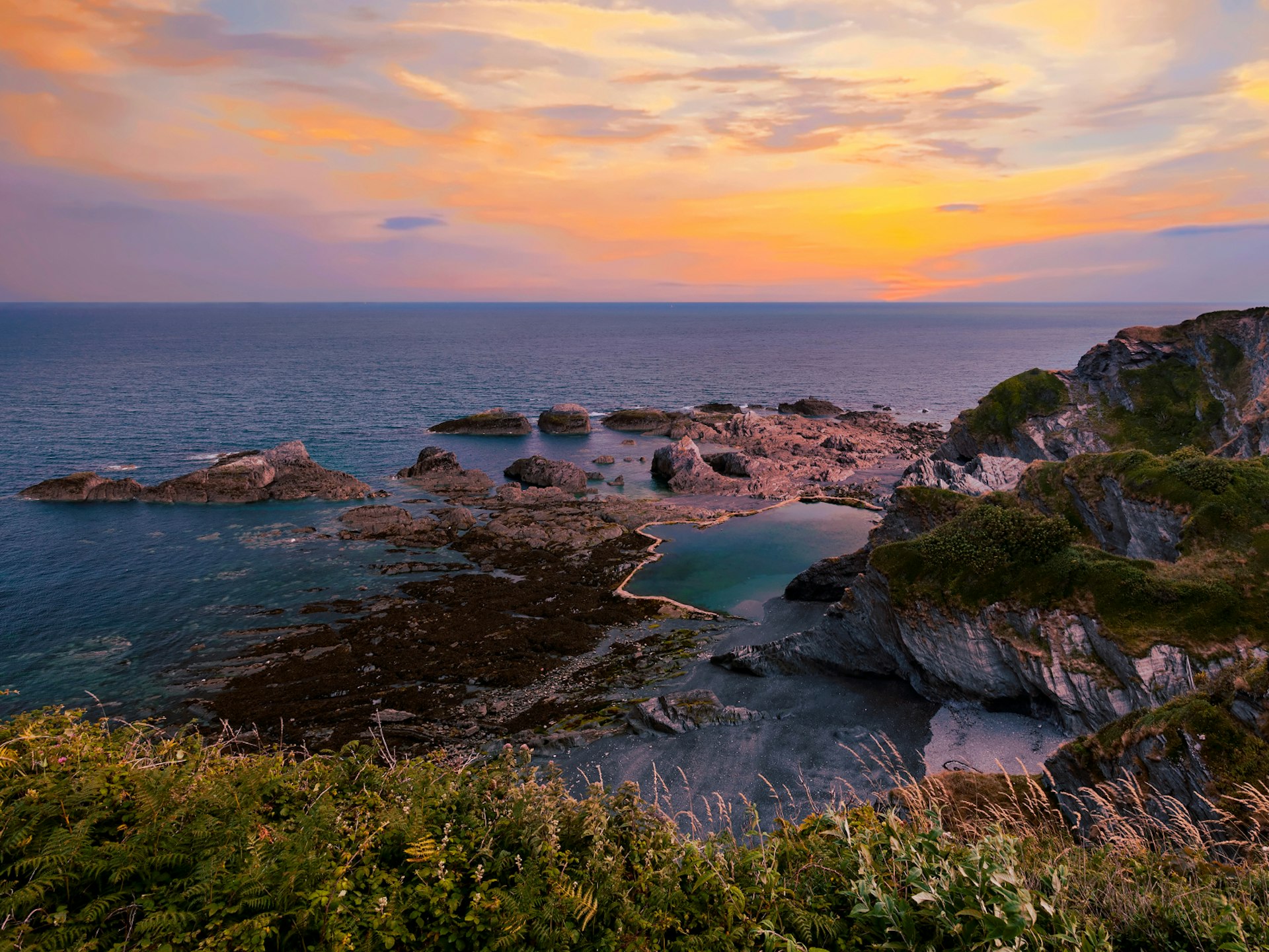 A sunset over the rocks pools of Tunnels Beaches in Devon