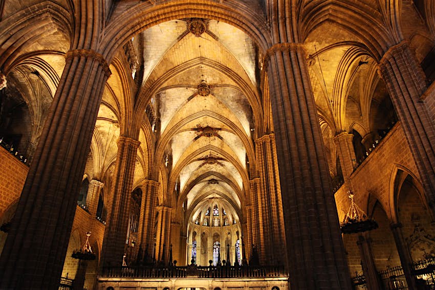 The vaulted Gothic interior of La Catedral in Barcelona, ​​a broad, soaring space divided into a central nave and two aisles by lines of elegant, slim pillars
