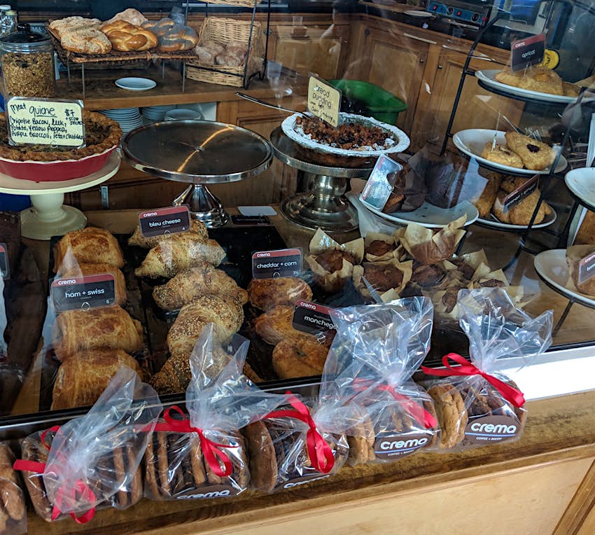 Rows of scones, biscuits and bagels are lined up under a glass display case at a cafe in Portland