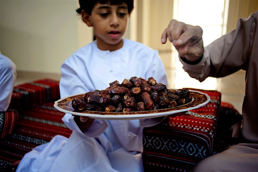 A boy offers a plate of dates to break the fast during Ramadan