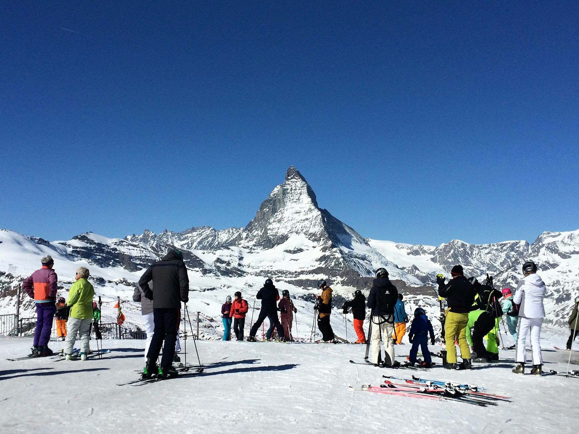 Skiers prepare to go down from the Gornergrat mountain with the Matterhorn mountain in the background