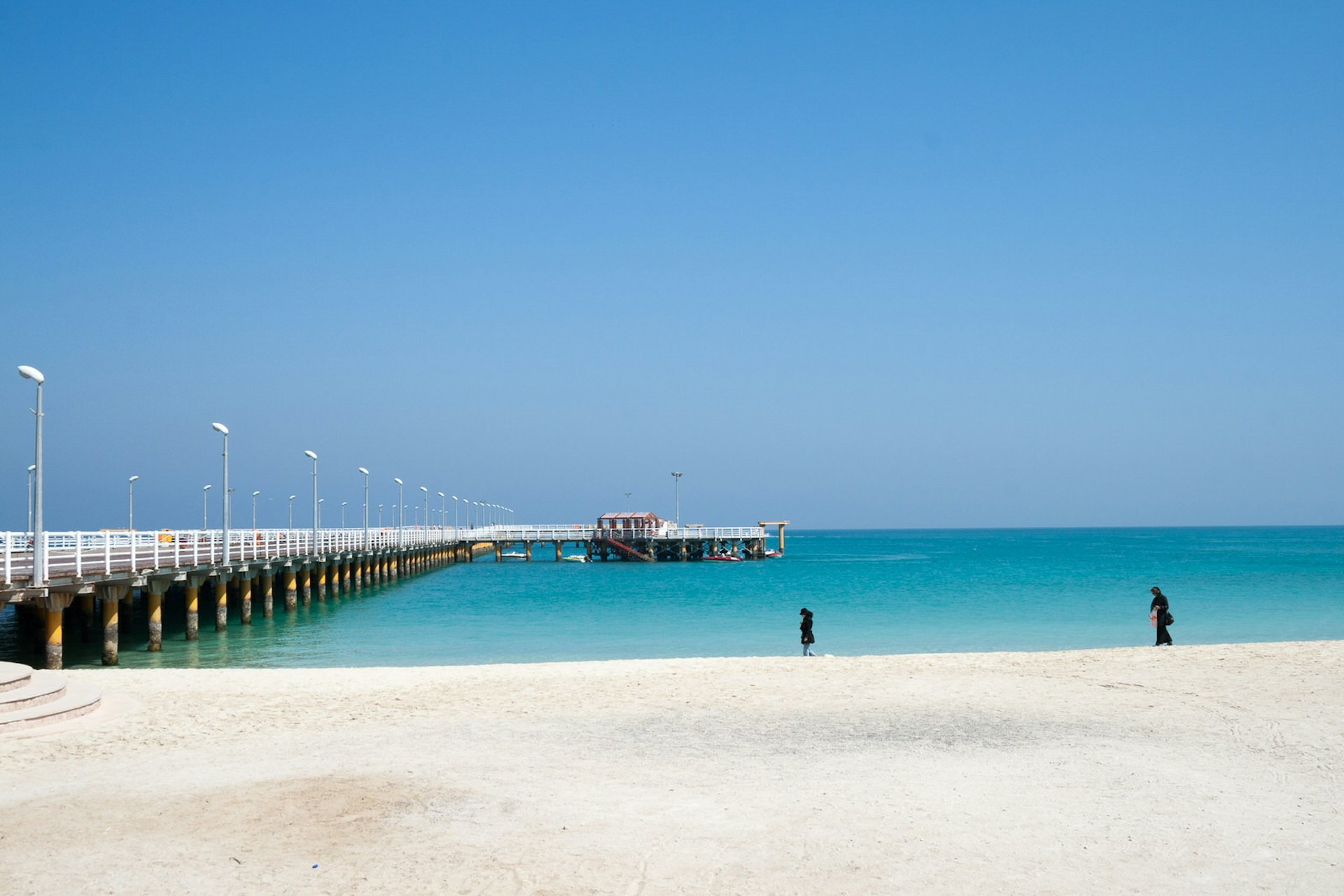 The Grand Recreational Pier of Kish Island, Iran, jutting from the sandy beach area into the azure-blue waters of the Gulf 