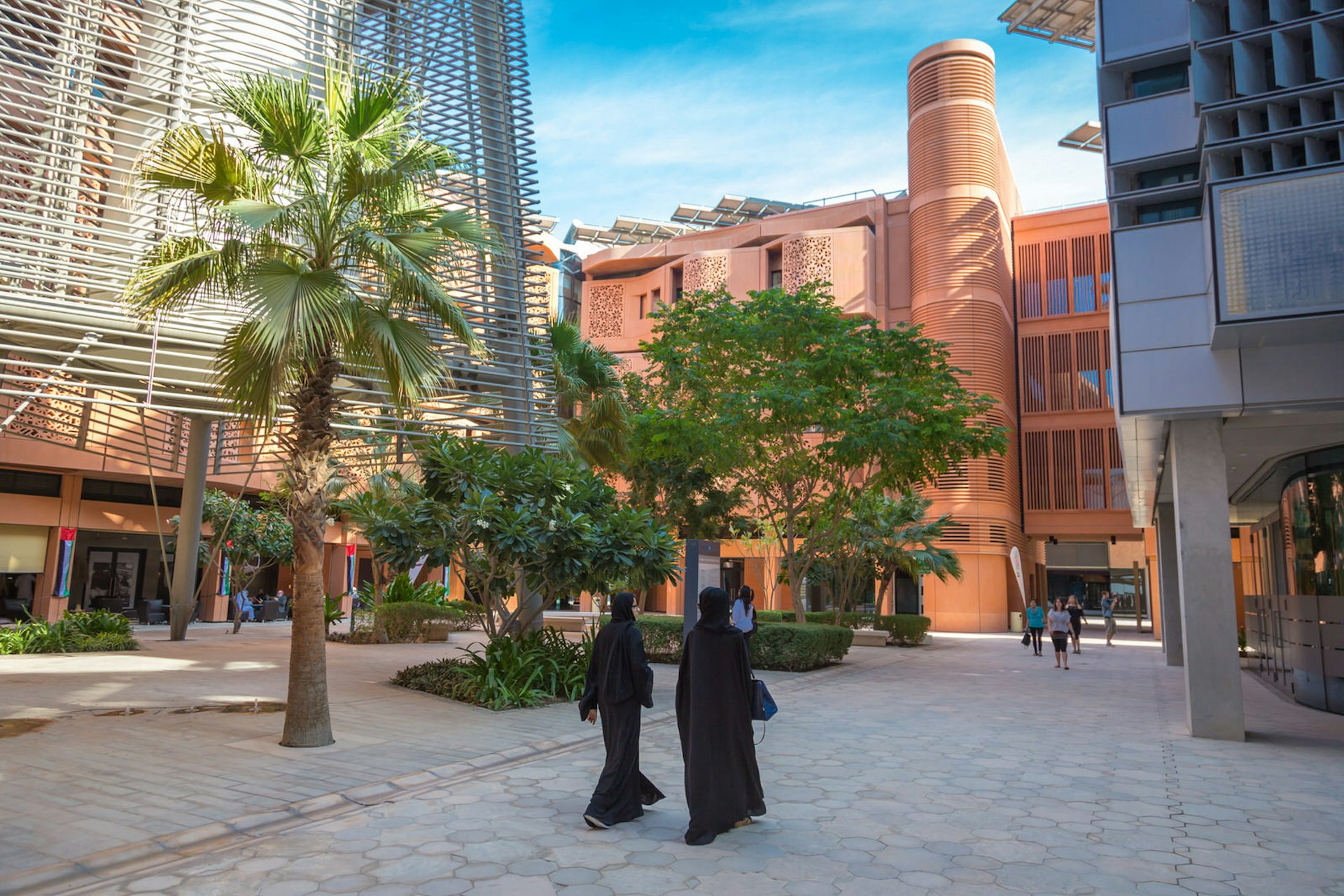 Two women walk through Masdar City, a project that aims to build the first sustainable city in the world