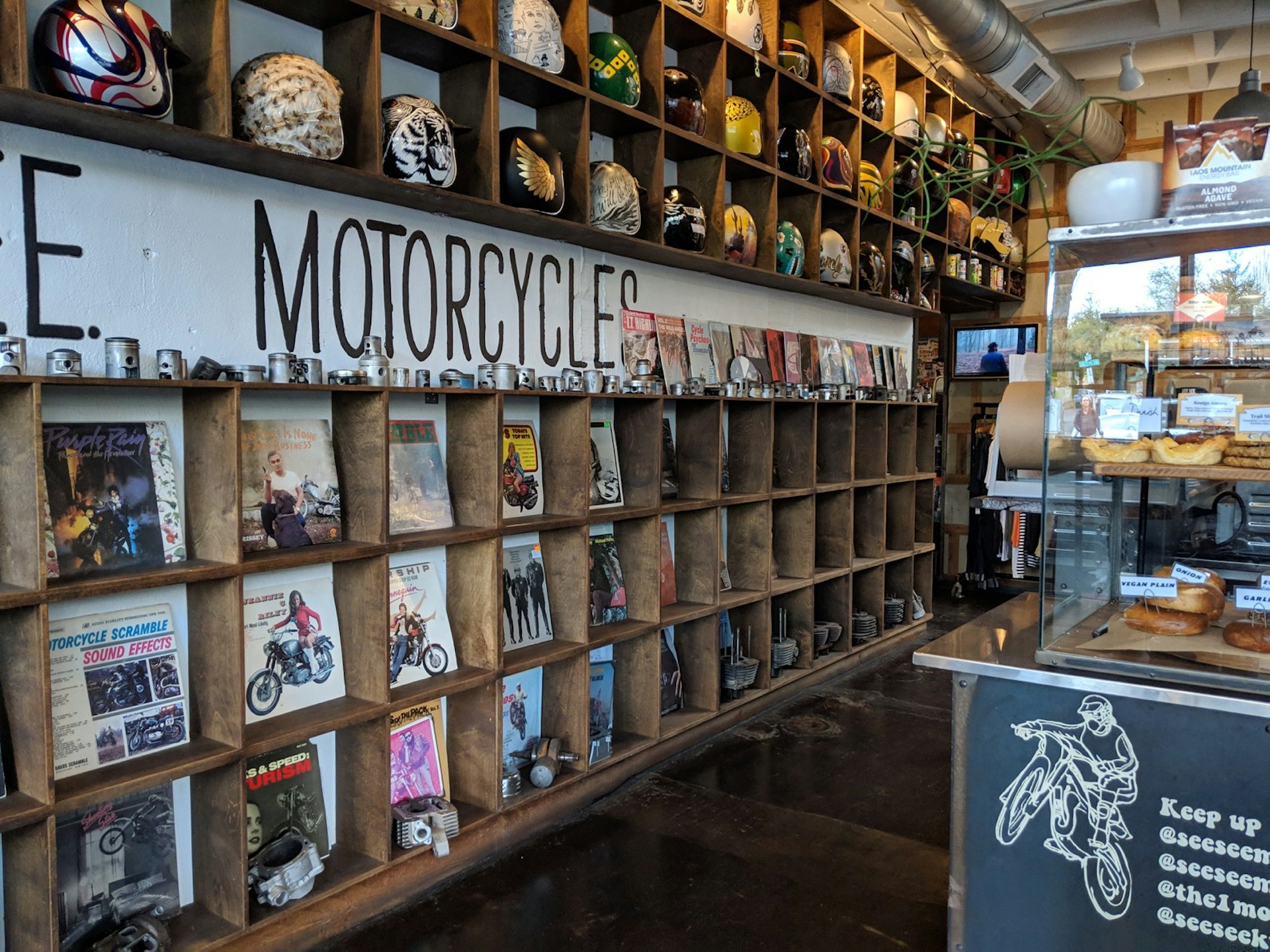 A wall of motorcycle helmets frames a cafe counter in Portland