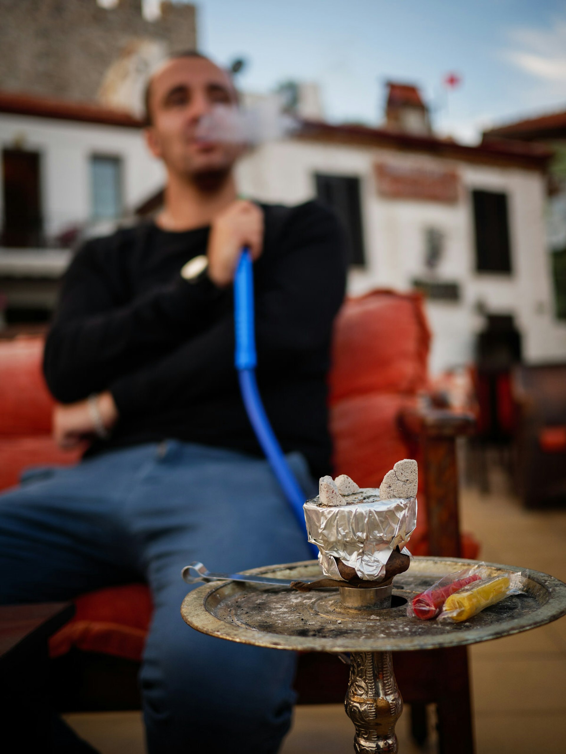A man smokes shisha outside