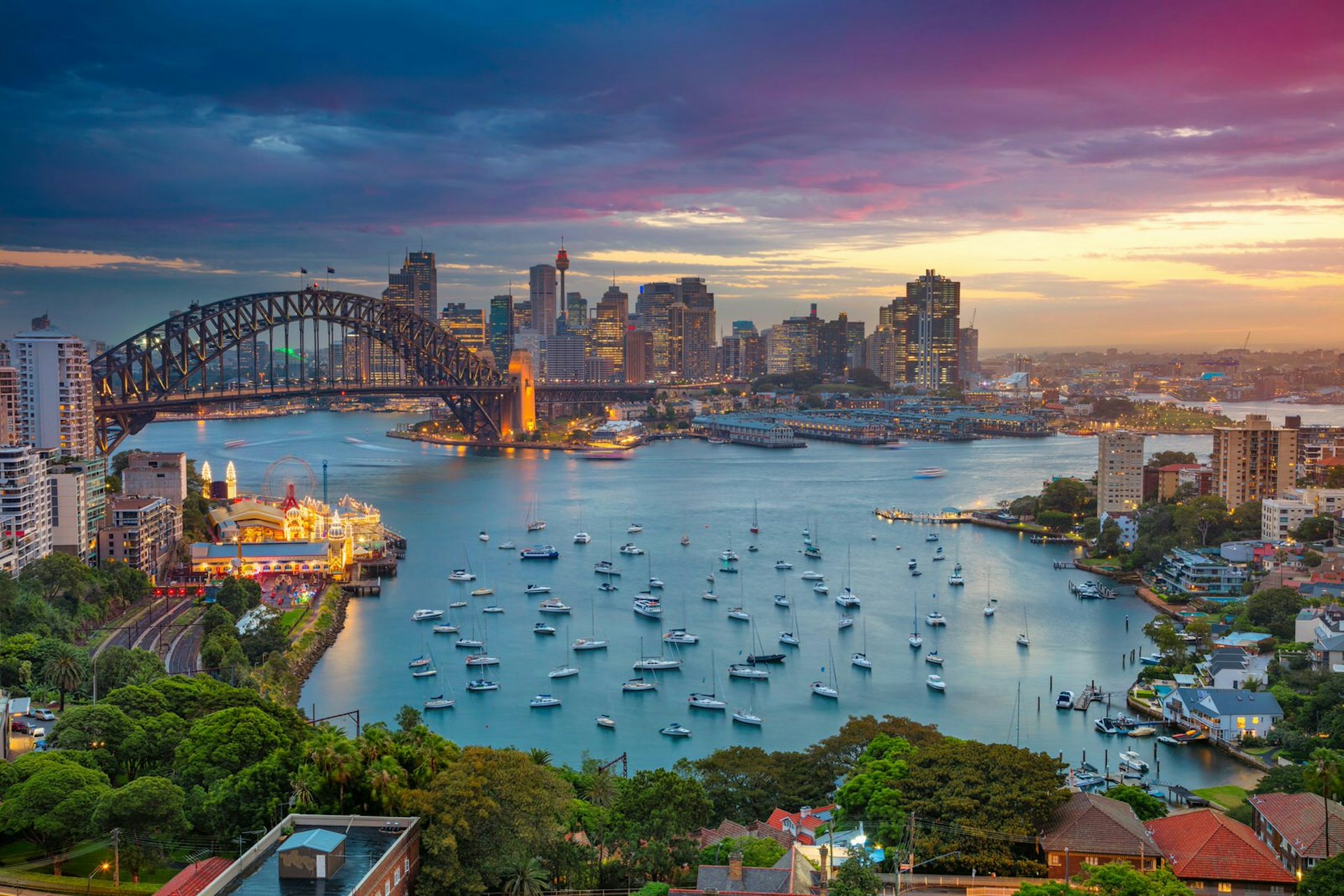 Cityscape image of Sydney, Australia with Harbour Bridge and Sydney skyline during sunset