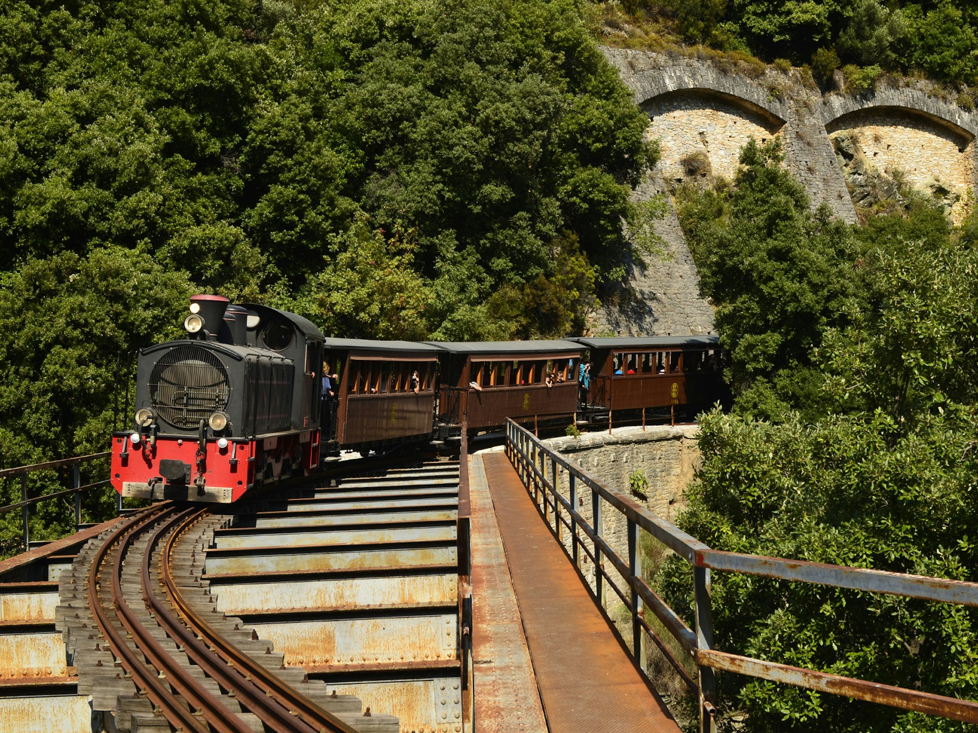 The heritage tourist train crossing a bridge in the mountains of Pelion