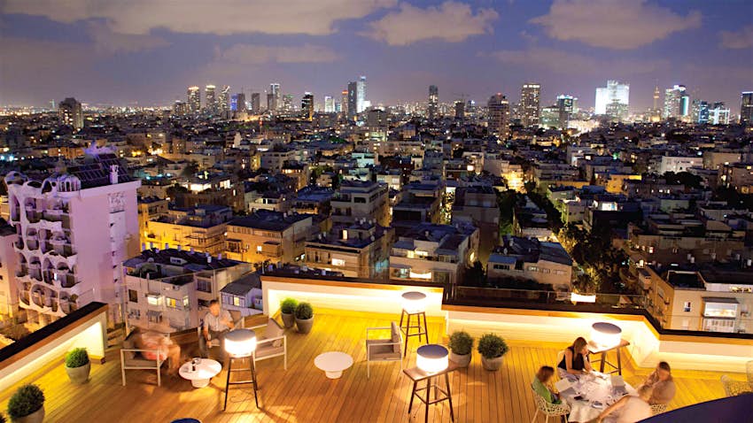 People sit at tables at the Blue Sky restaurant atop the Carlton Tel Aviv hotel
