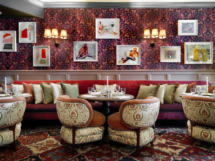 Meghan Markle London - The dining room at Dean Street Townhouse, where Meghan Markle and Prince Harry are said to have had their first date. Image shows a decadent dining room in tones of red and wine with lots of fancy art on the walls as well as plush chairs. © Soho House