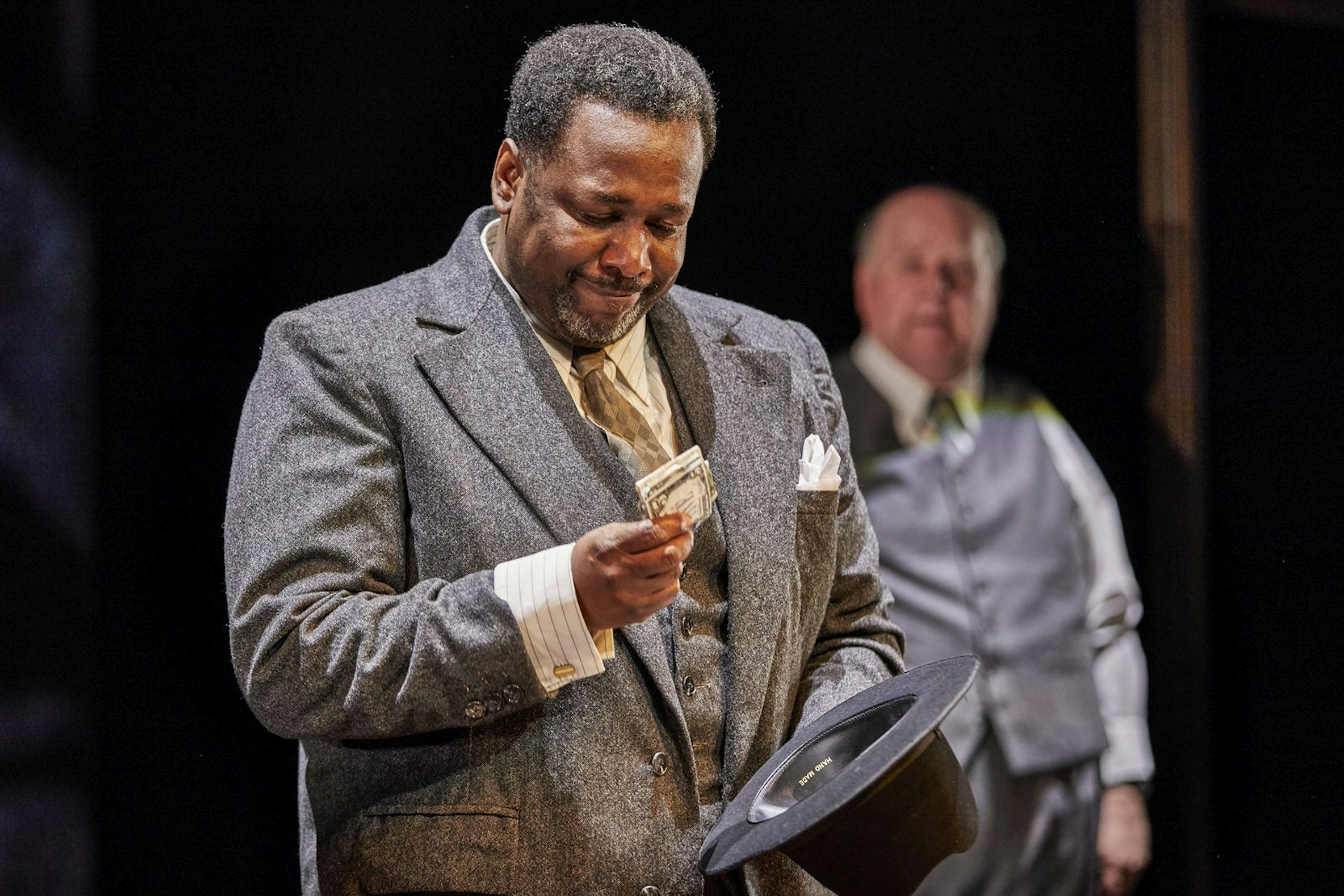 Celebrities West End Broadway - The Wire's Wendell Pierce in Death of a Salesman at the Old Vic, London. Wendell looks down at some money clenched in his hand © Brinkhoff Mogenburg