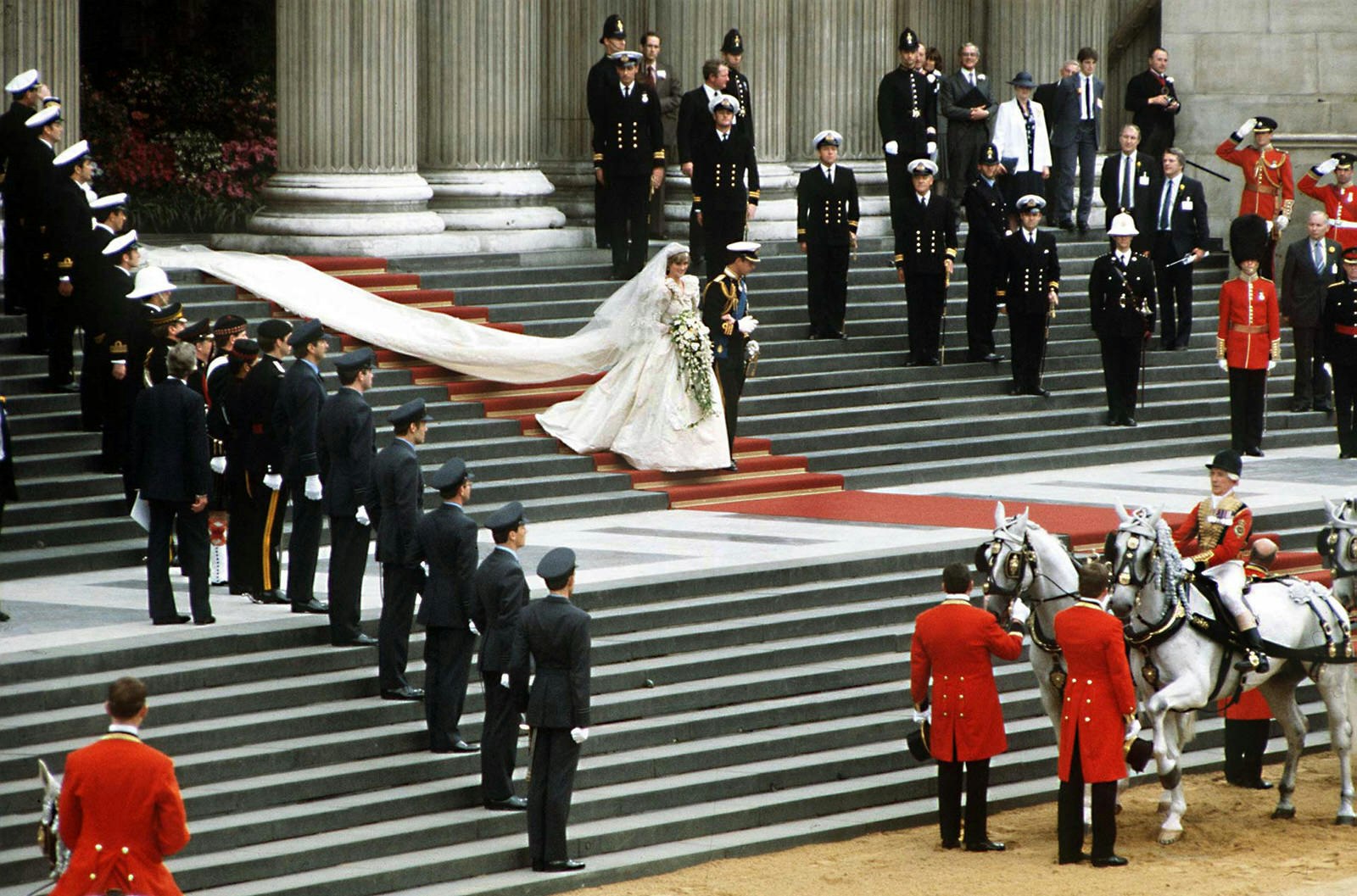 The steps of St Paul's Catheral are lined with uniformed service people as Charles and Diana (with remarkable dress train in tow) make their way down the red carpet steps to a waiting horse-drawn carriage© Jayne Fincher / Princess Diana Archive / Getty Images