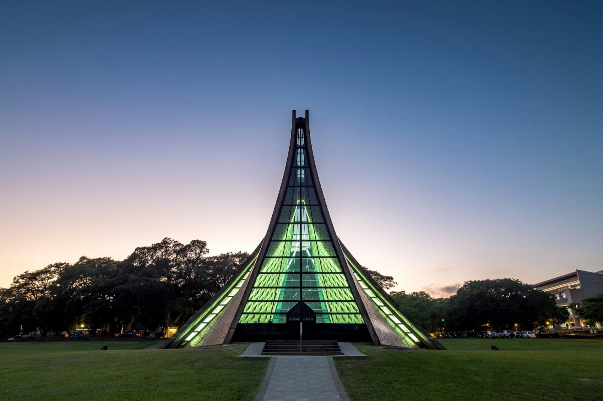 The Luce Memorial Chapel a tee pee shaped structure glows green in twighlight
