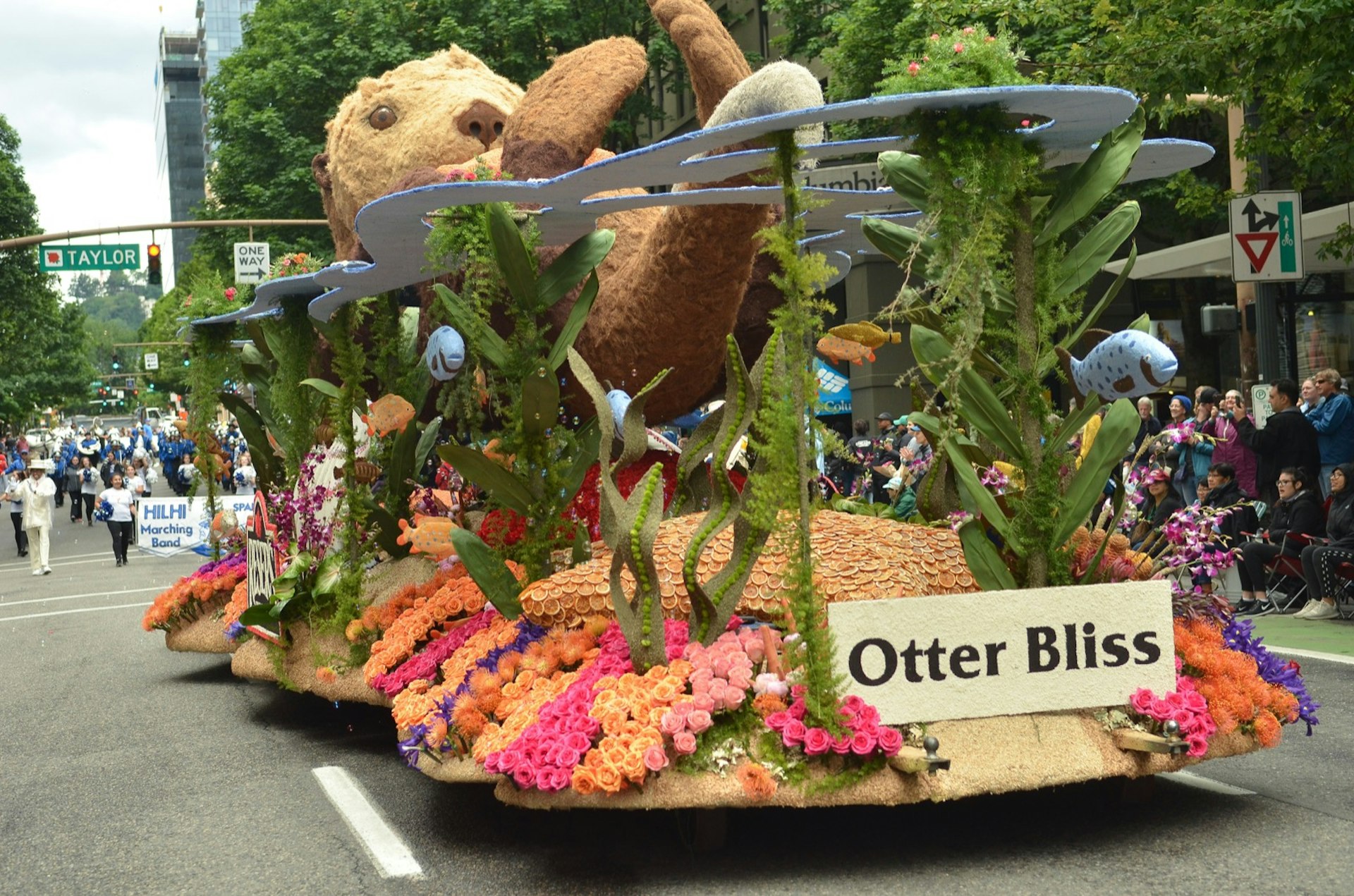A float moves down a street in Portland, depicting an otter on its back