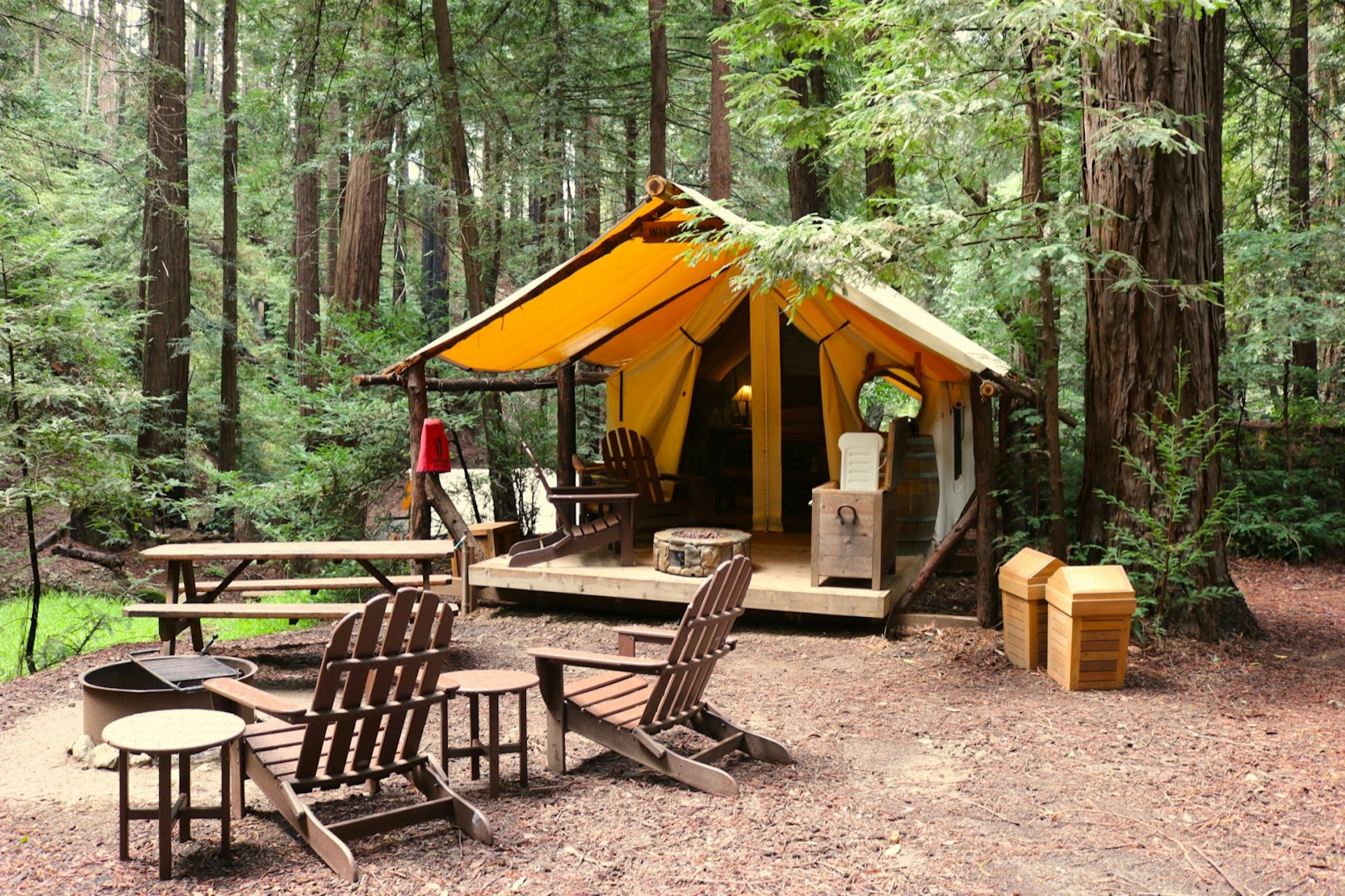 Adirondack椅子围绕着火坑，带有野生动物园风格的帐篷