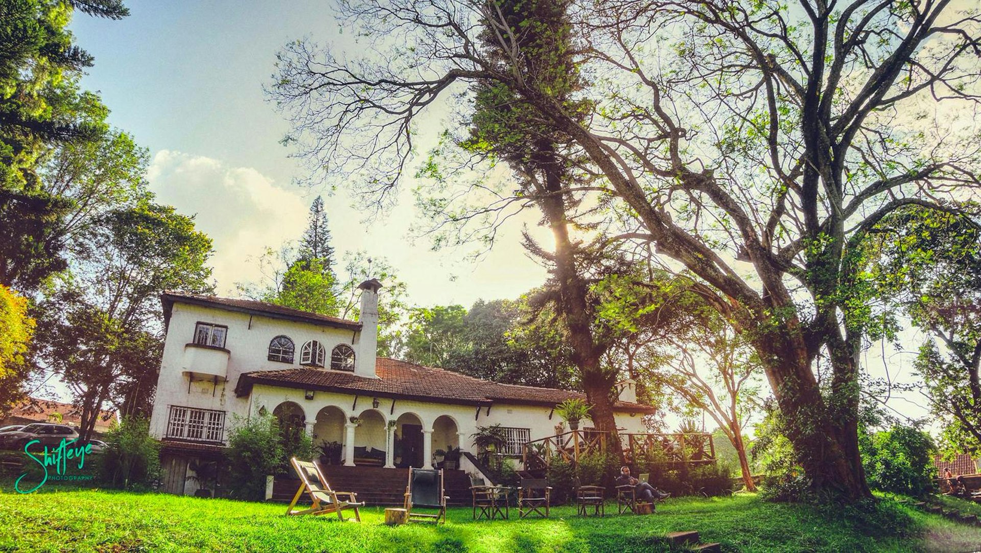 Nairobi June - A stately mansion with arches over its verandah sits beneath trees, with lovely lawns in the foreground; yoga here is one of the best things to do in Nairobi in June