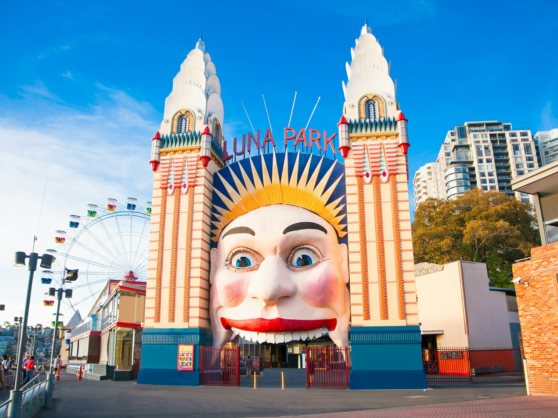 Disney alternatives - Mr Moon, the gatekeeper to a world of adventure at Luna Park. A huge pale face framed by skyscrapers is the entrance to Luna Park - with visitors entering through its mouth 