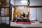 Two monks hunch over paperwork at Eko-in