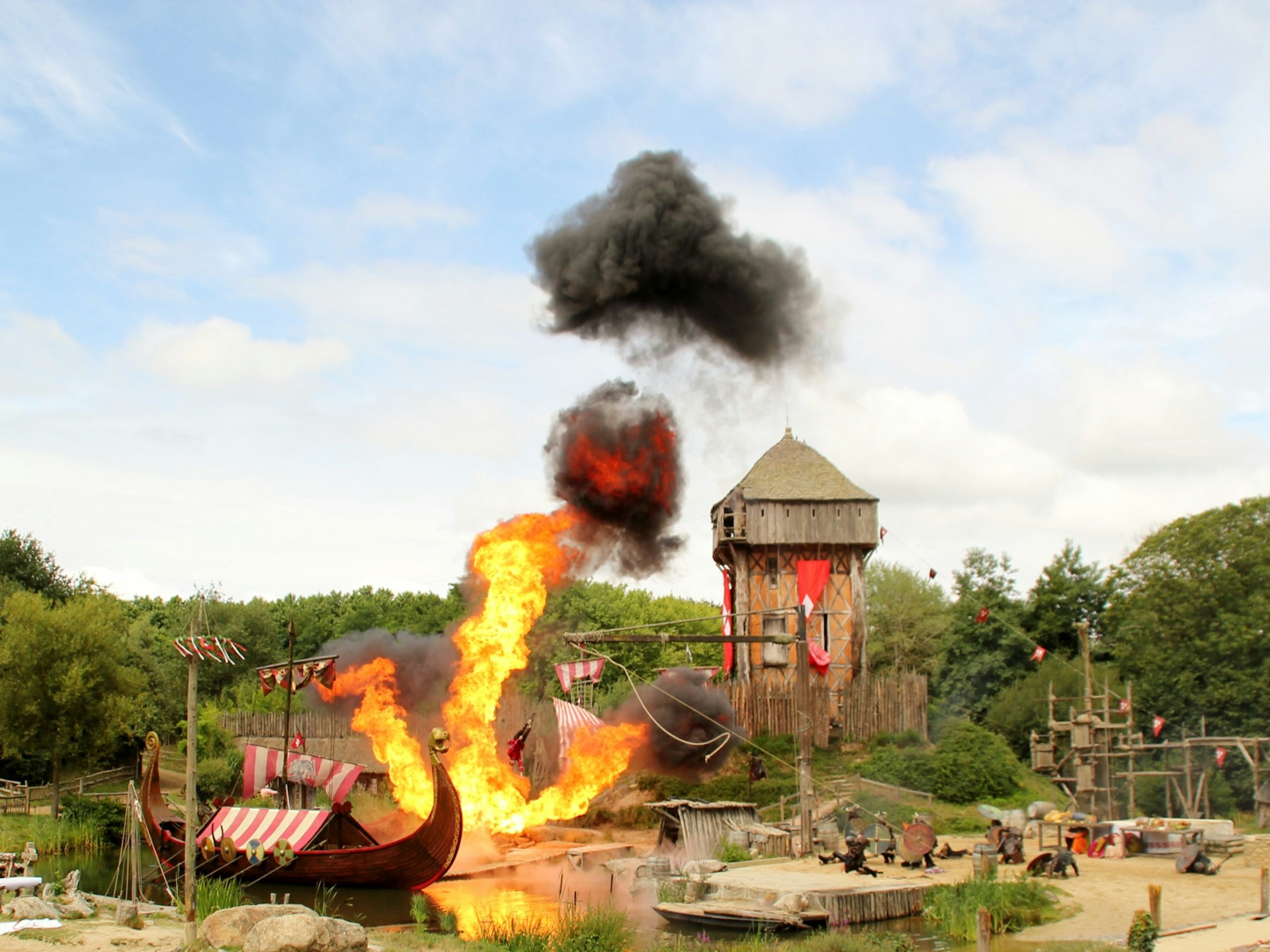 Disney alternatives - A viking re-enactment show at Puy du Fou shows a viking boat bursting into flames next to a wooden tower 
