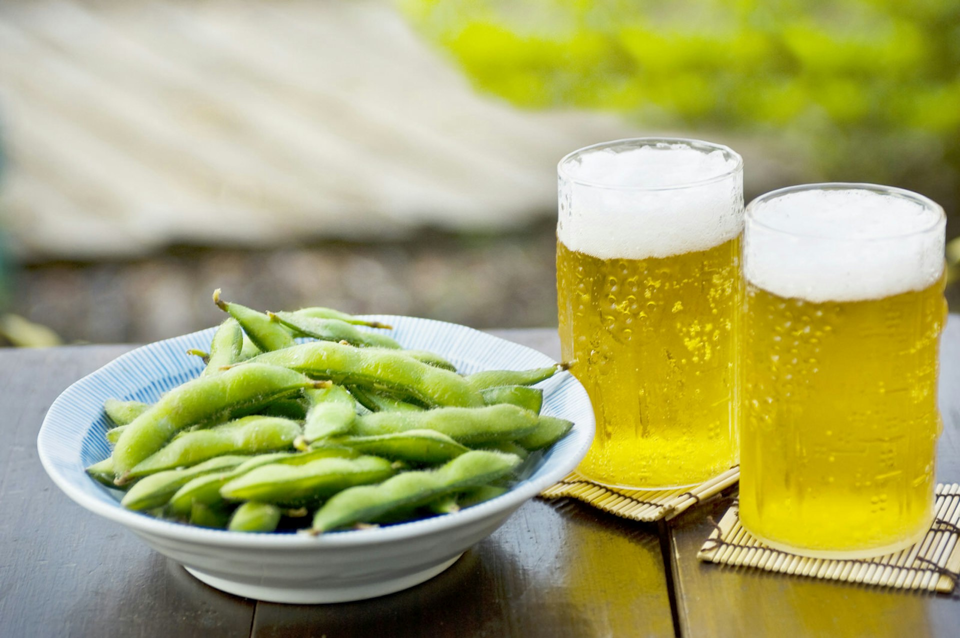 Tokyo summer - Two beers and a bowl of edamame beans are pictured on a table in the sunshine 